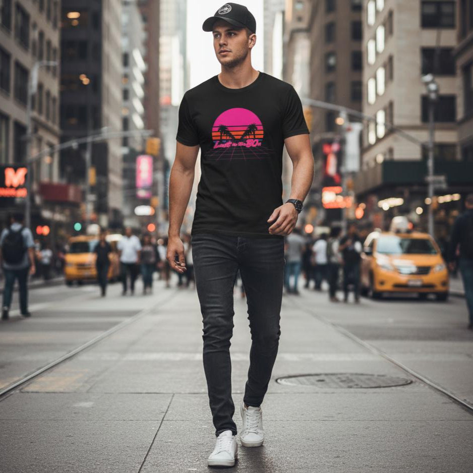 Man walking on a city street wearing a black t-shirt with a colorful graphic design.