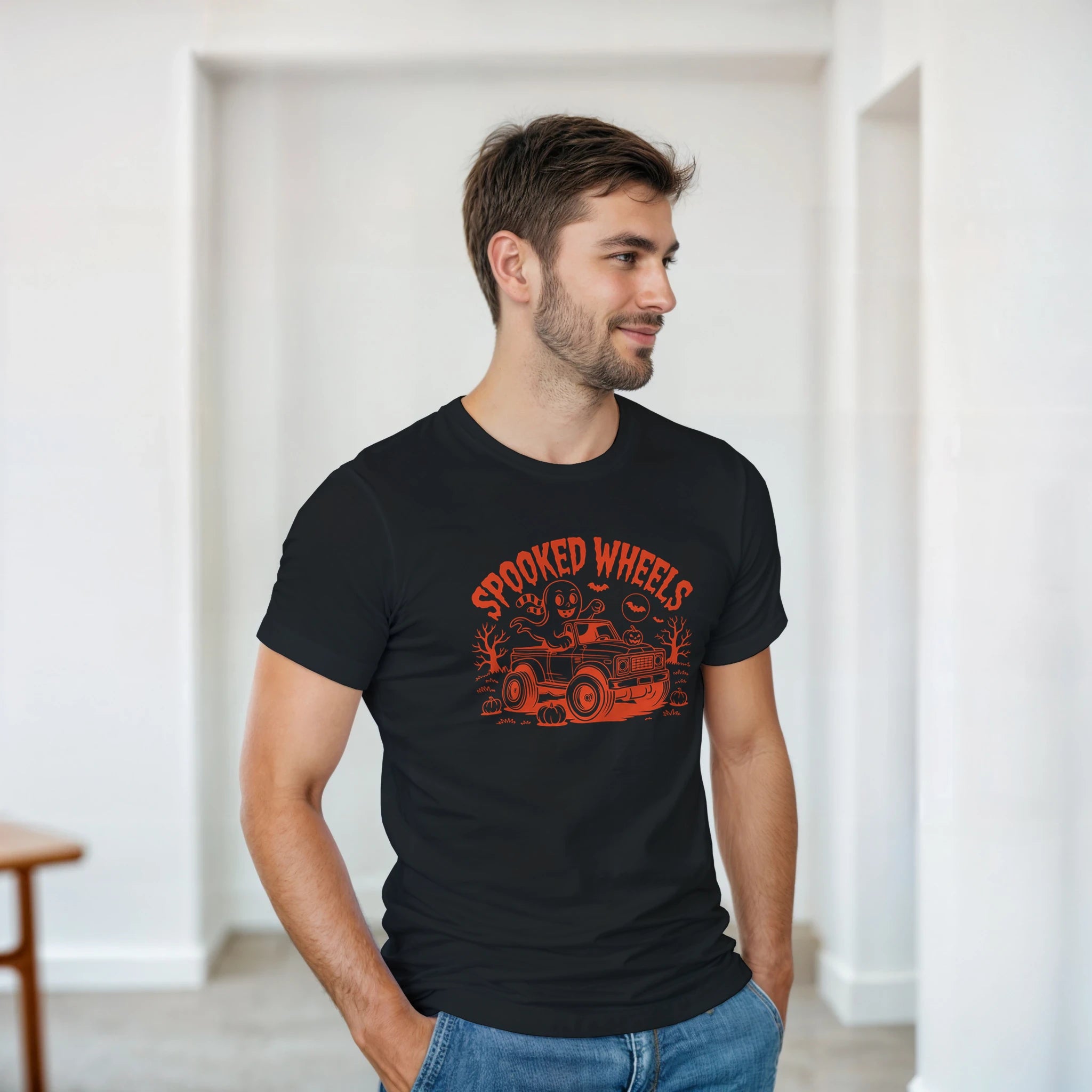 Man wearing a black t-shirt with red graphic design in a minimal indoor setting