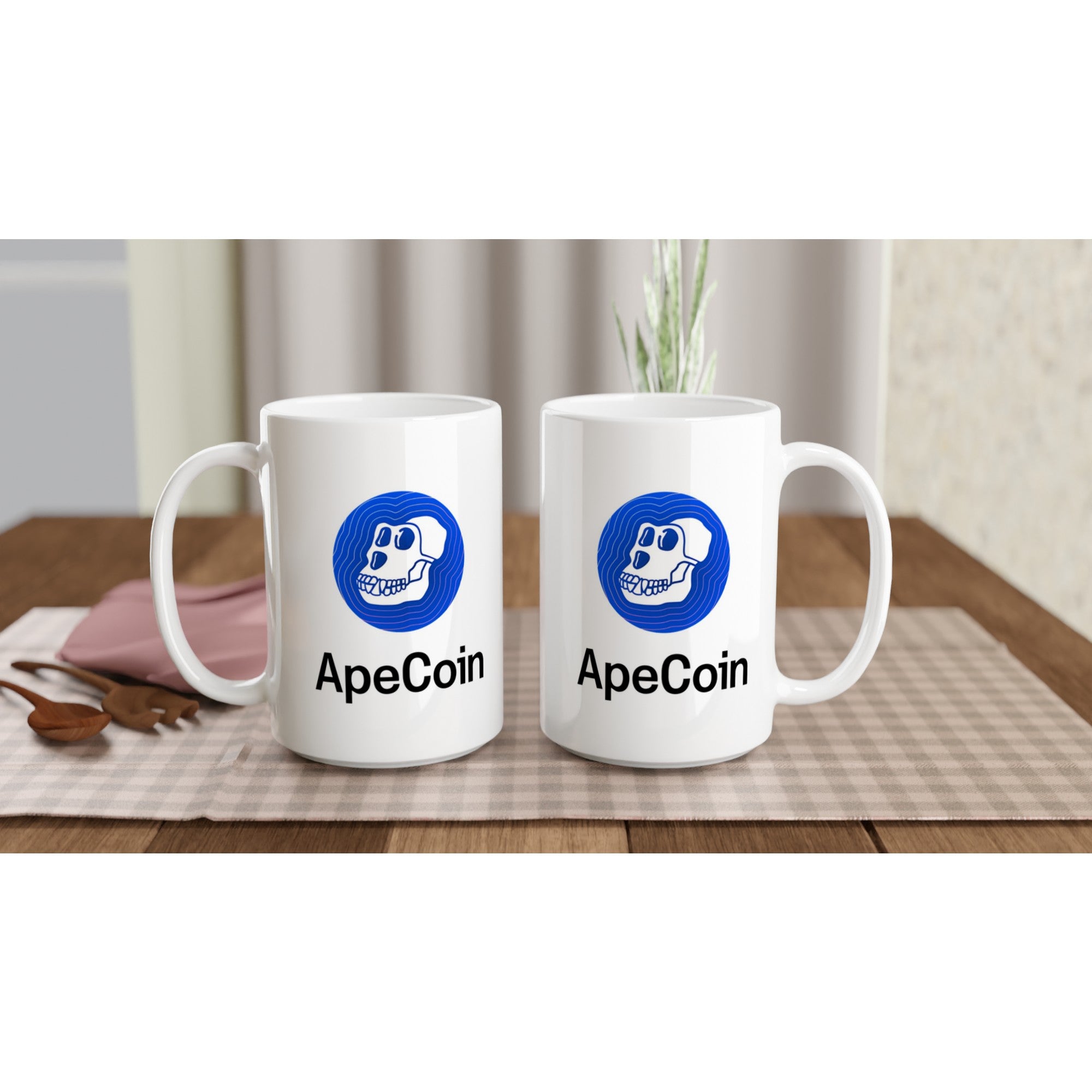 Two white mugs with ApeCoin logo on a wooden table