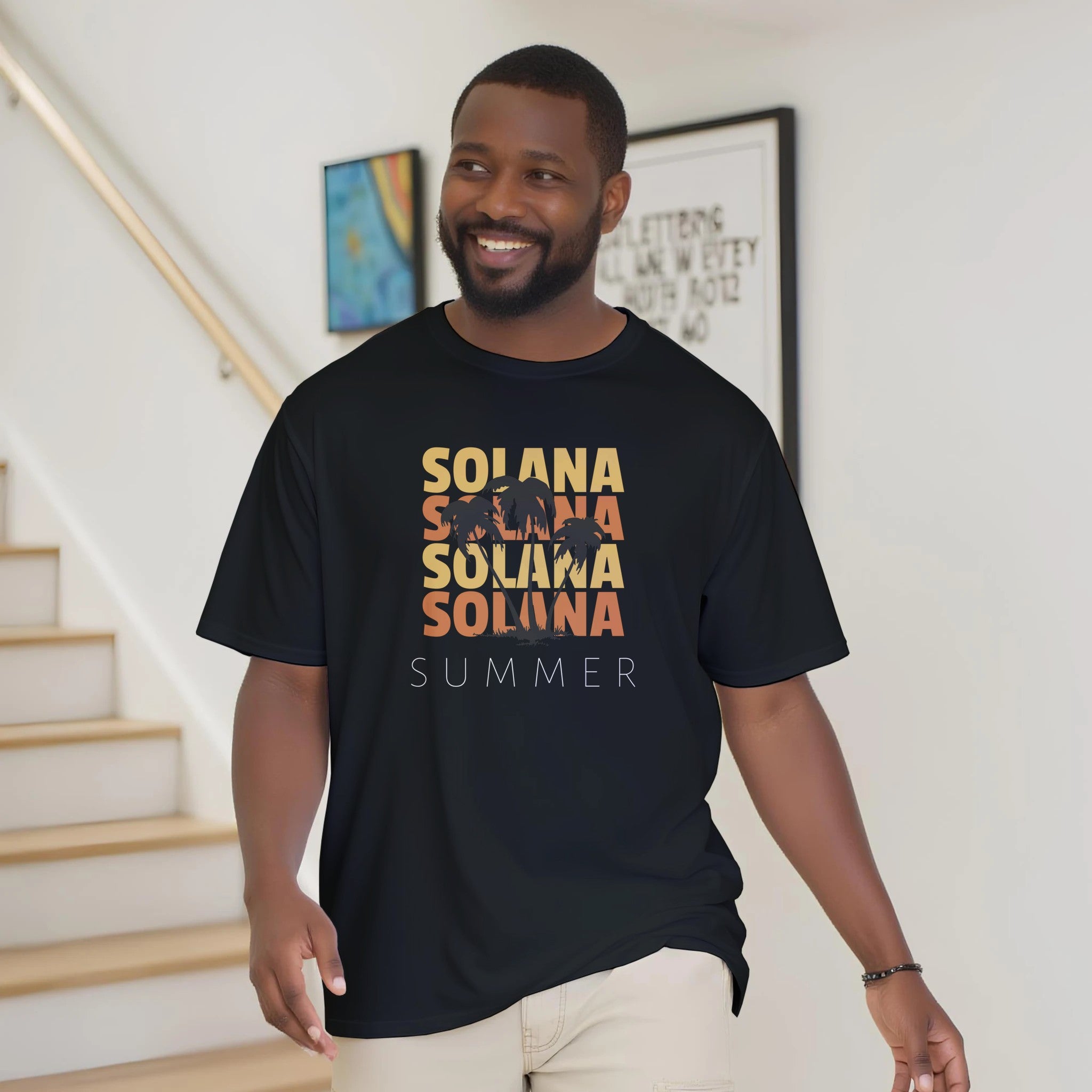 Man wearing a black t-shirt with 'SOLANA SUMMER' text in multiple colors, standing indoors.