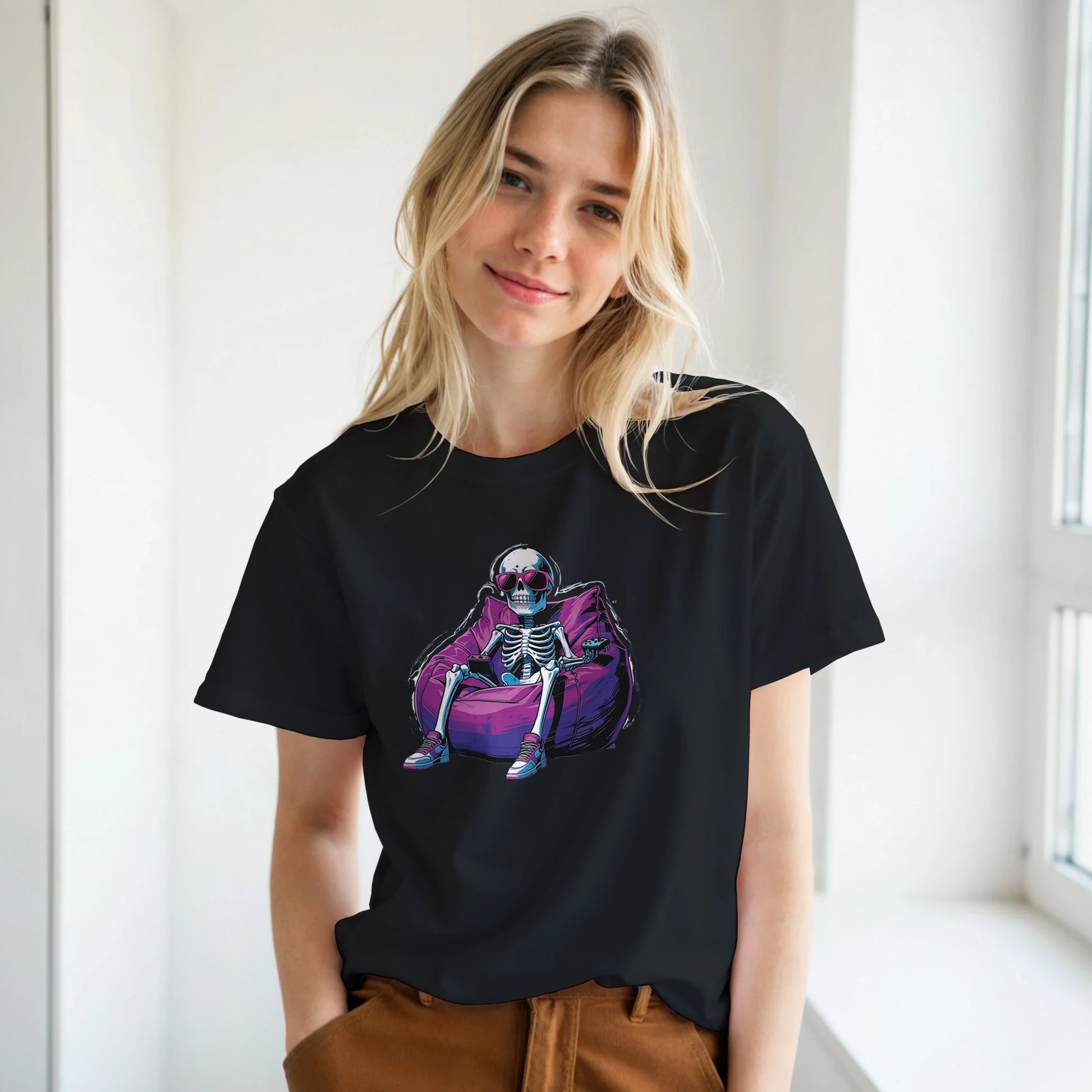 Person wearing a black t-shirt with a colorful graphic design of a skeleton on a purple bag.