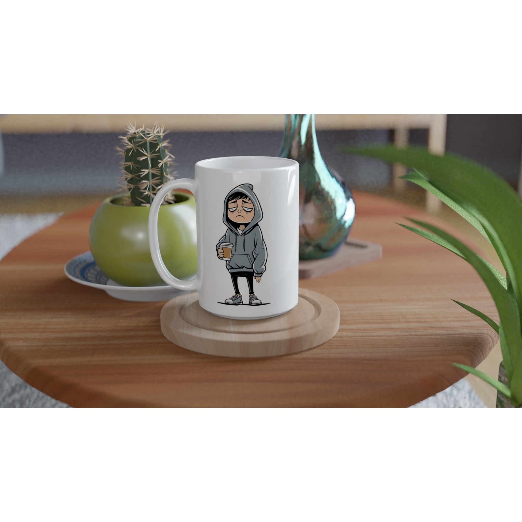 White mug with a graphic design on a wooden table with plants and a vase.