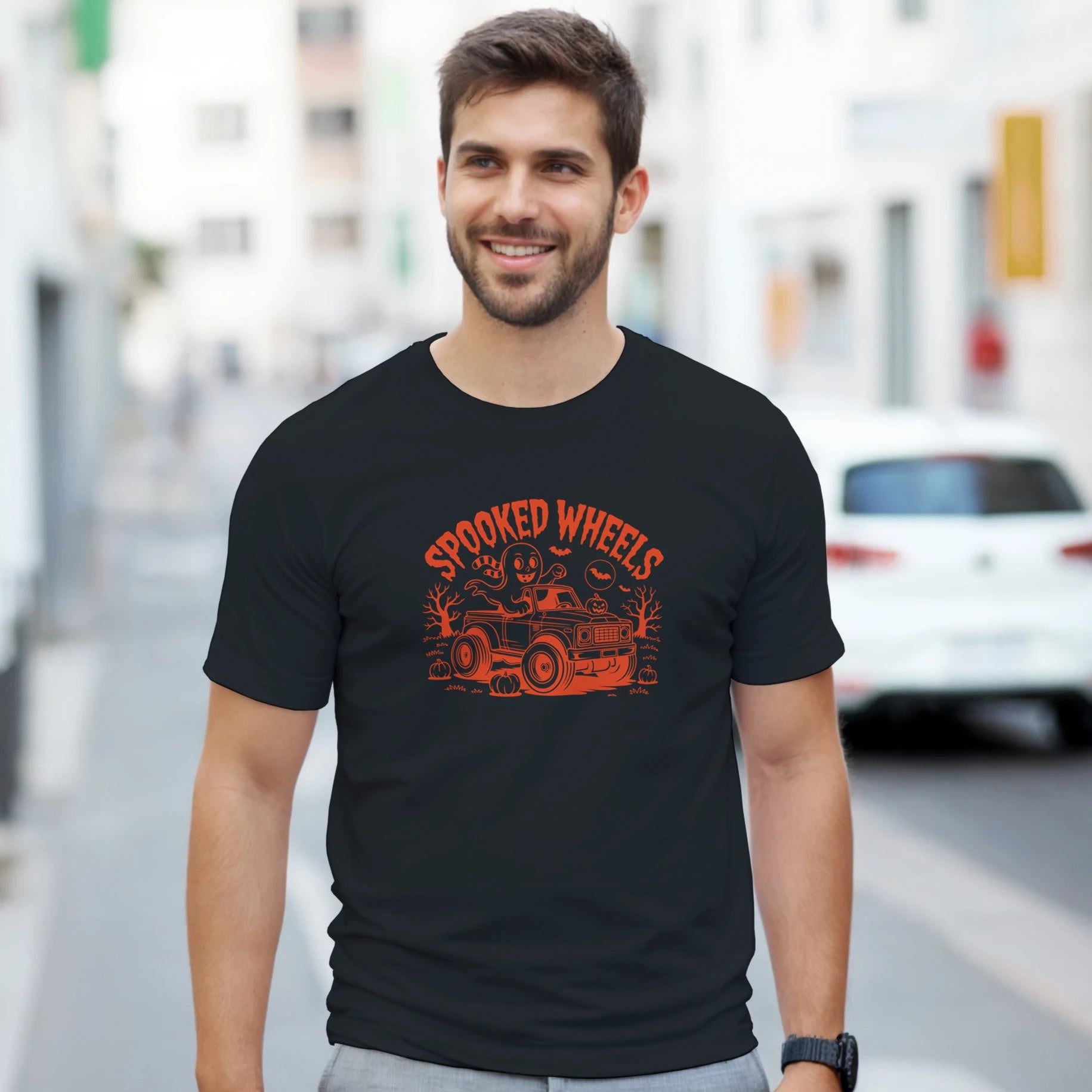 Man wearing a black t-shirt with red graphic design on a city street