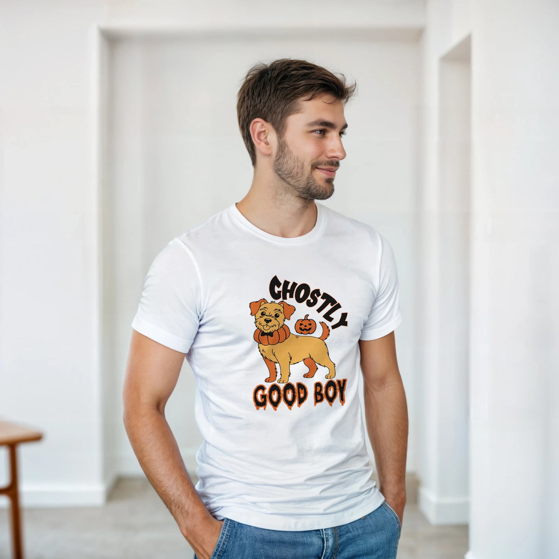 Man wearing a white t-shirt with a graphic of a dog and text 'Ghostly Good Boy' in a room.