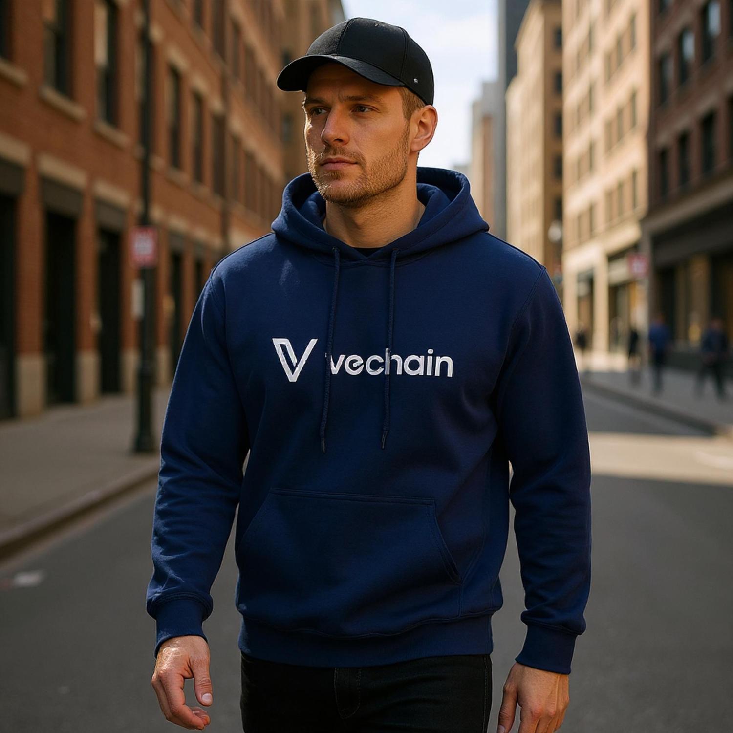 Man wearing a blue hoodie with 'vechain' logo on a city street