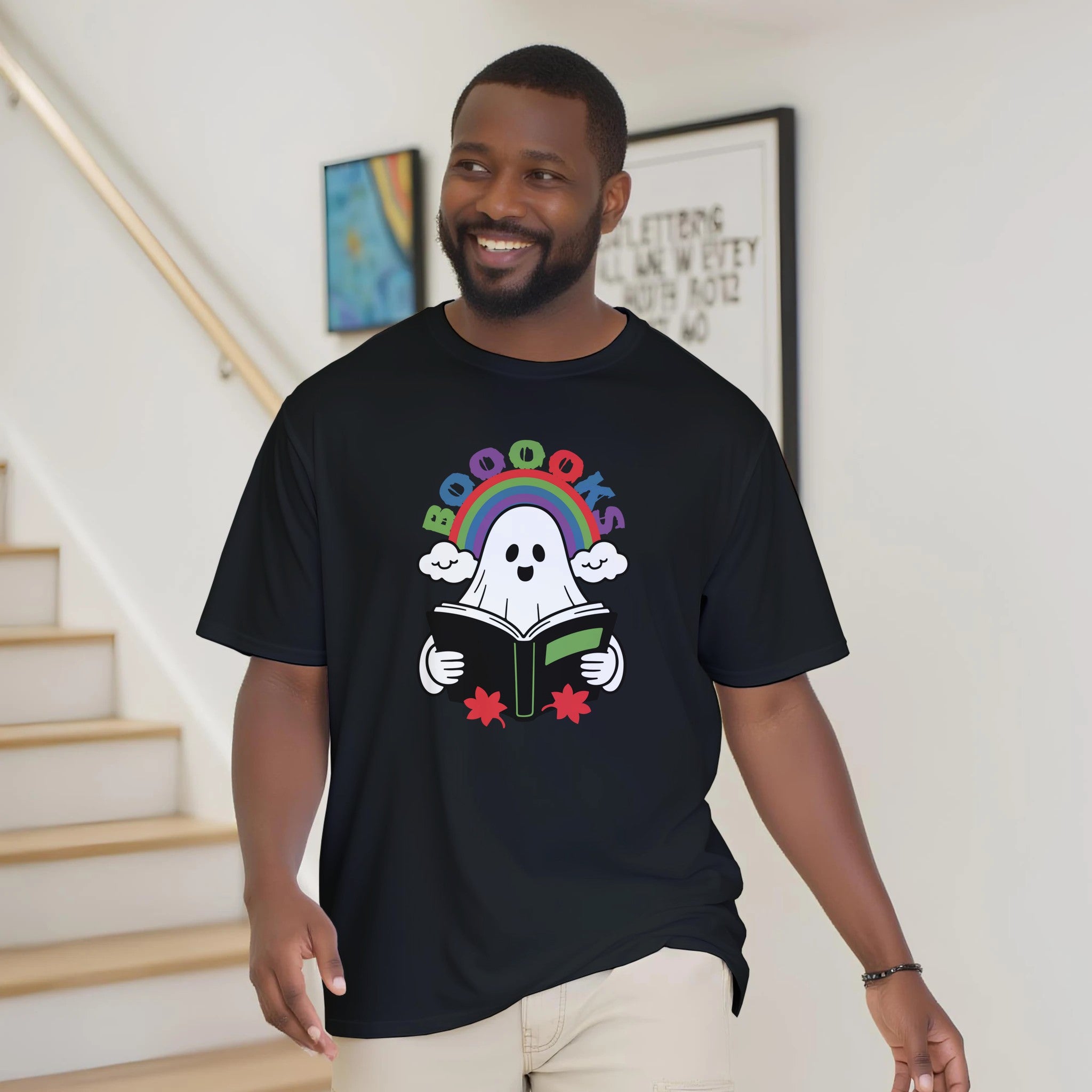 Man wearing a black t-shirt with a colorful graphic design, standing in a home setting.