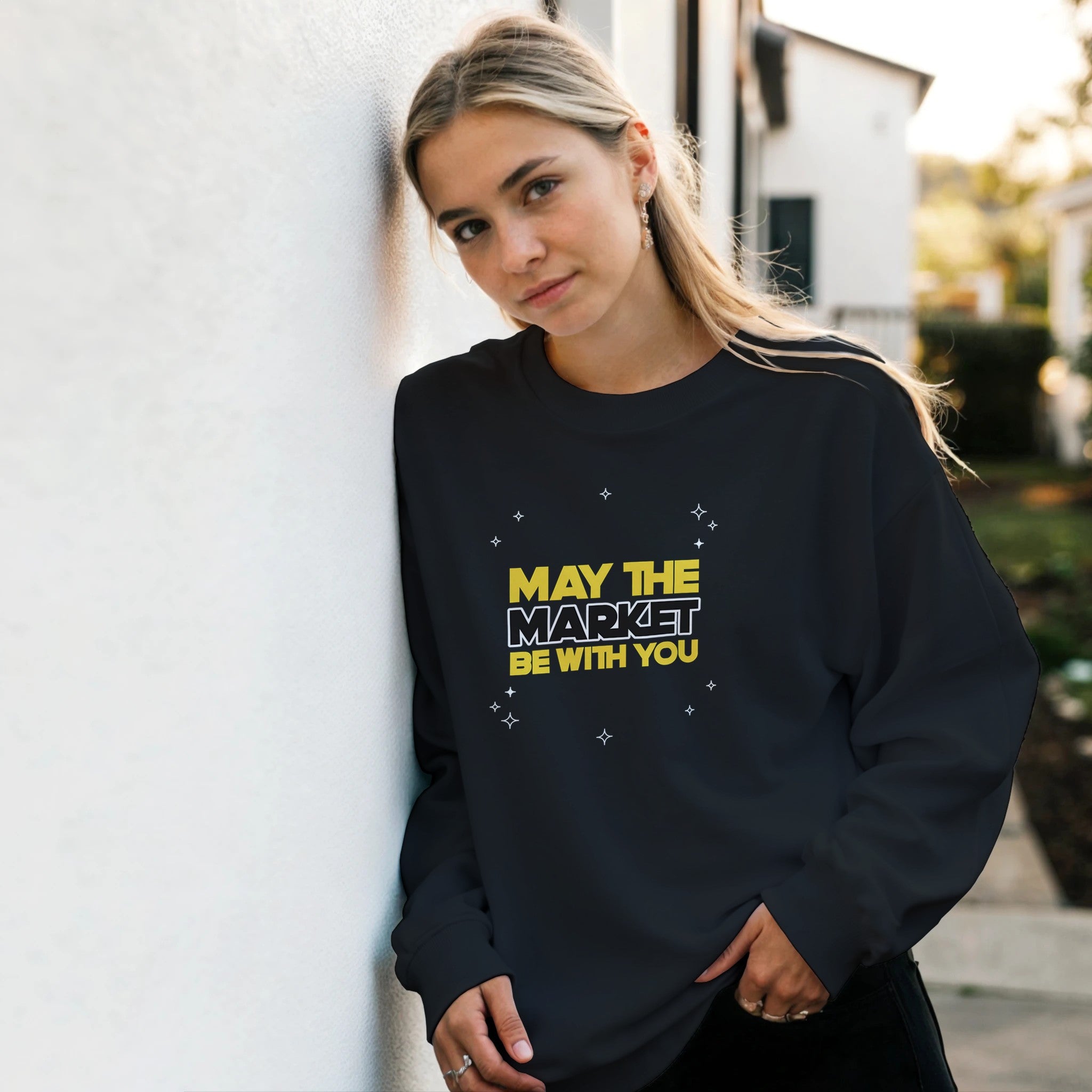 Person wearing a black sweatshirt with yellow text outdoors