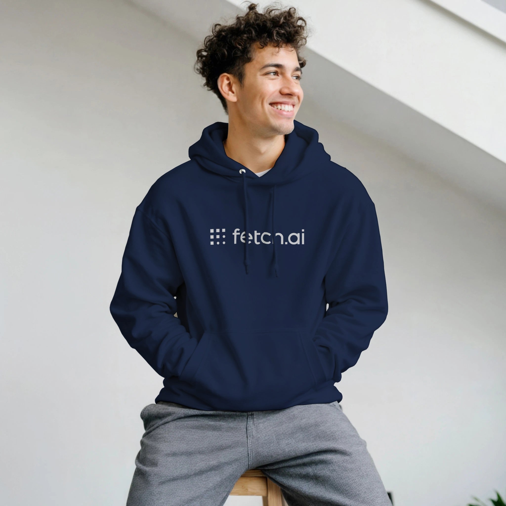 Person wearing a navy hoodie with 'fetch.ai' logo against a light background
