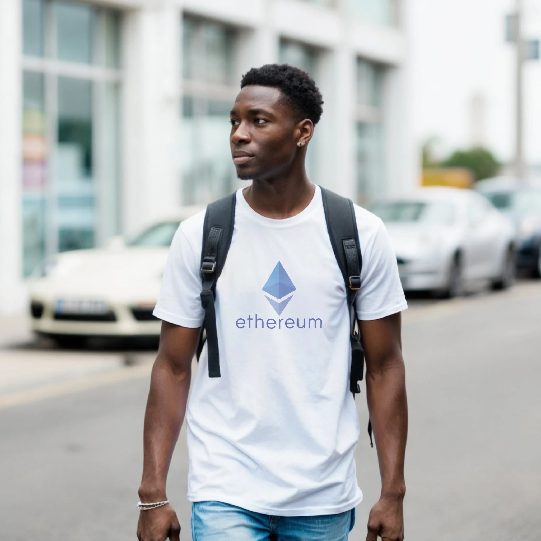 Man wearing a white t-shirt with Ethereum logo on a street