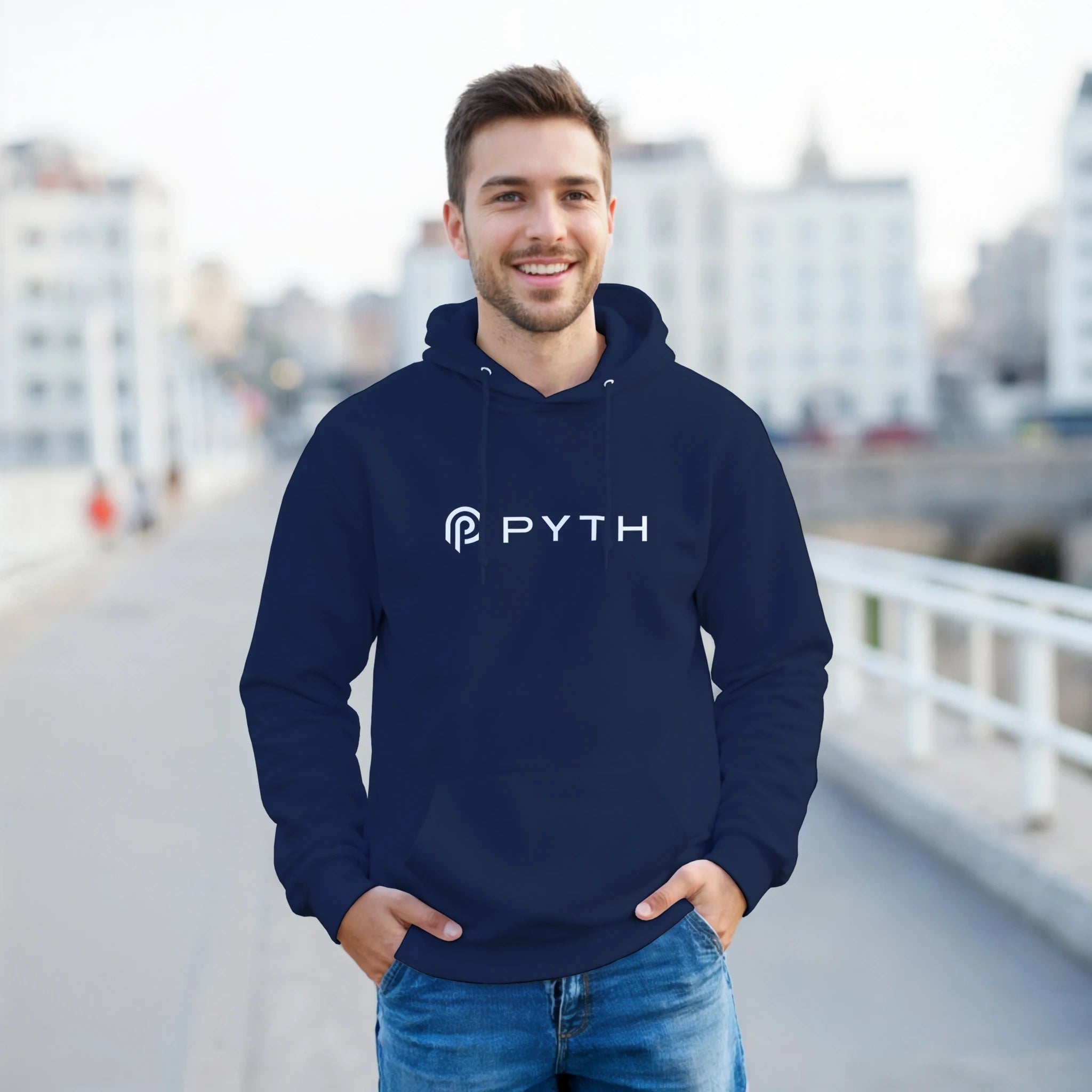 Man wearing a navy hoodie with 'PYTH' logo on a blurred city street background