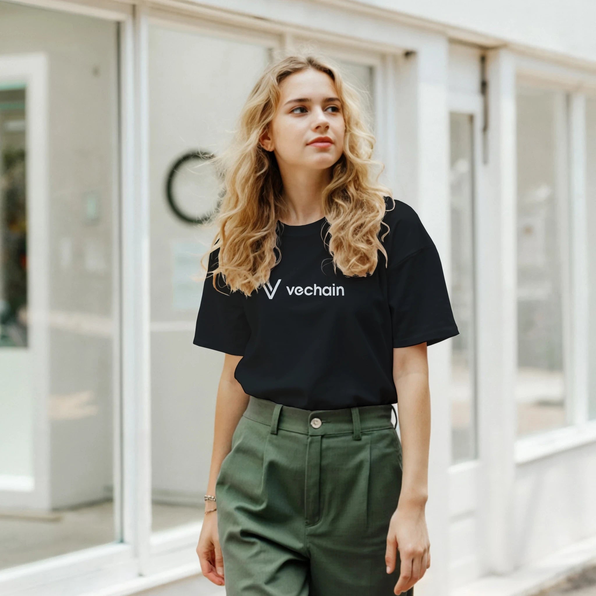 Woman wearing a black Vechain t-shirt in an indoor setting