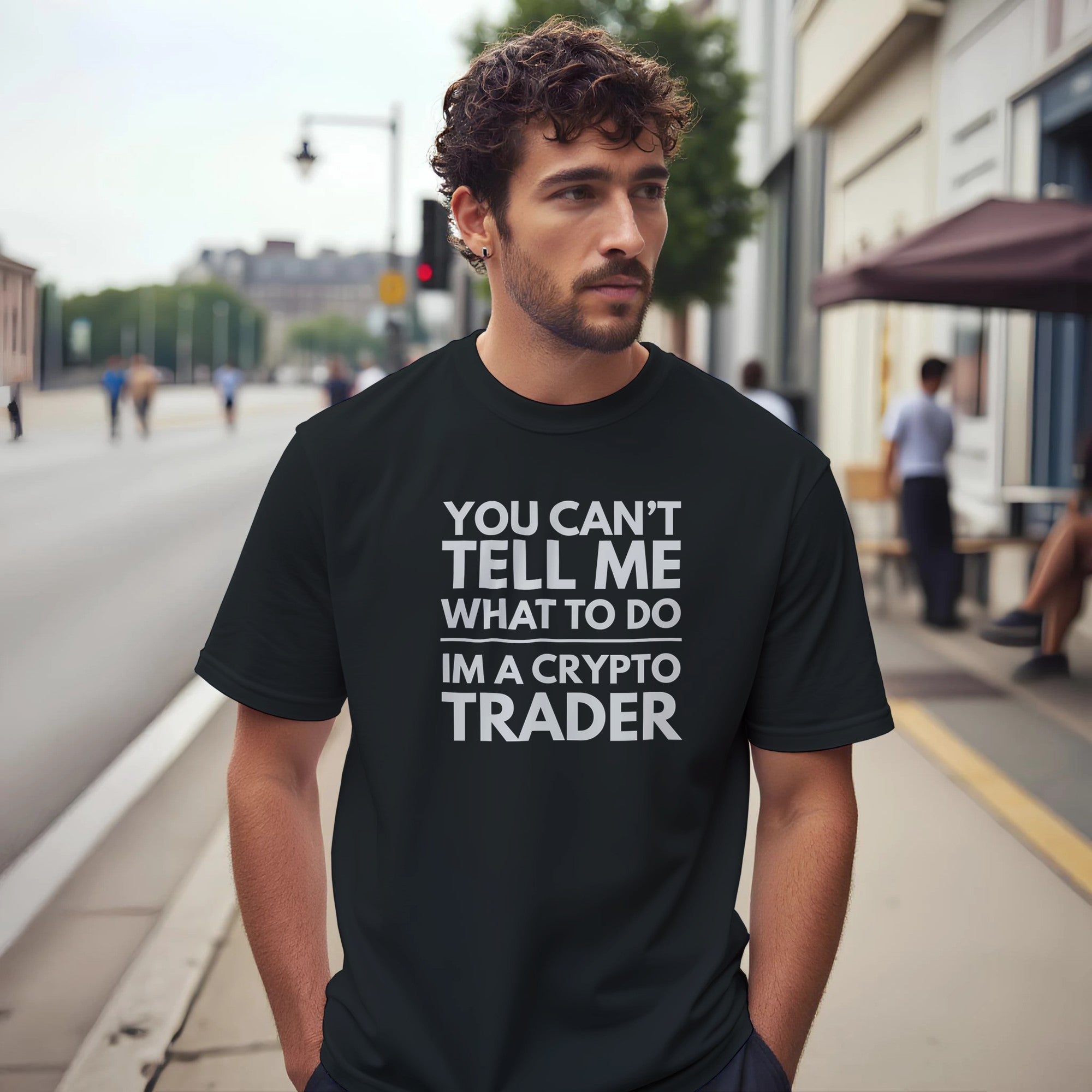 Man wearing a black t-shirt with a crypto trader message on a city street.