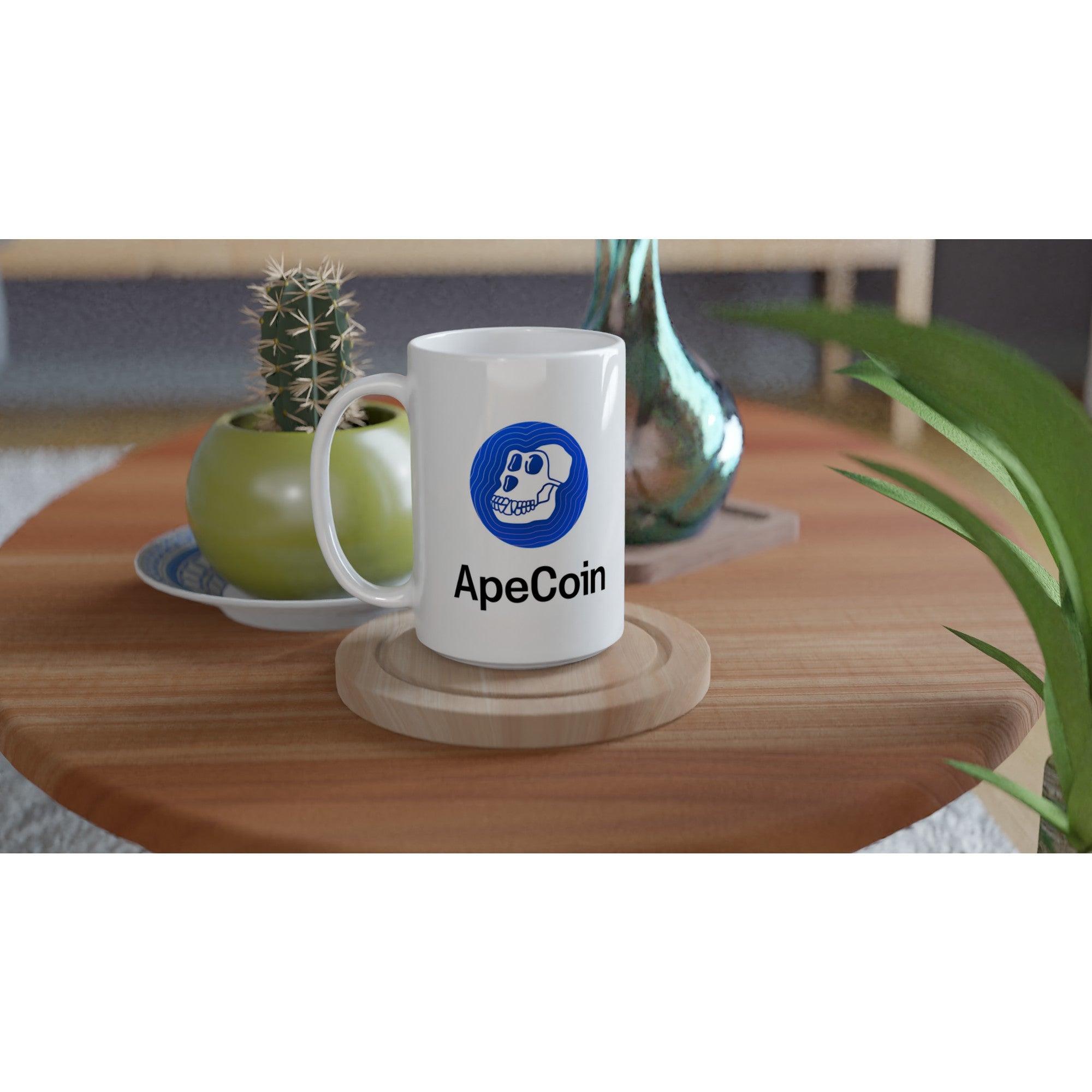 White mug with ApeCoin logo on a wooden table with plants and a plant pot in the background