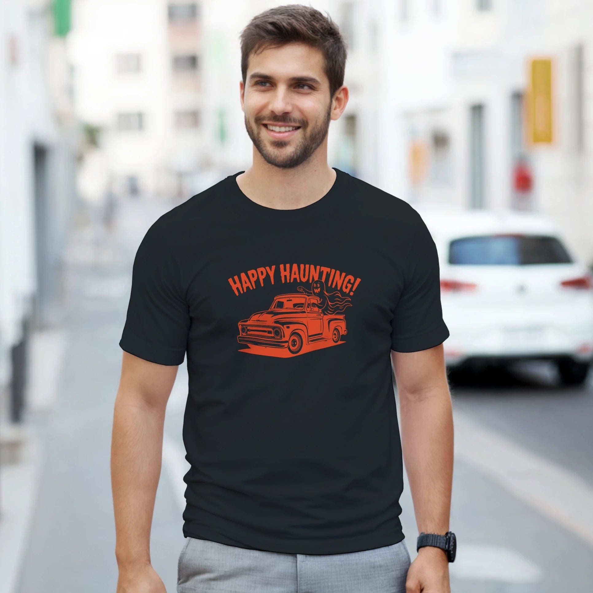 Man wearing a black t-shirt with 'Happy Haunting!' graphic on a city street.