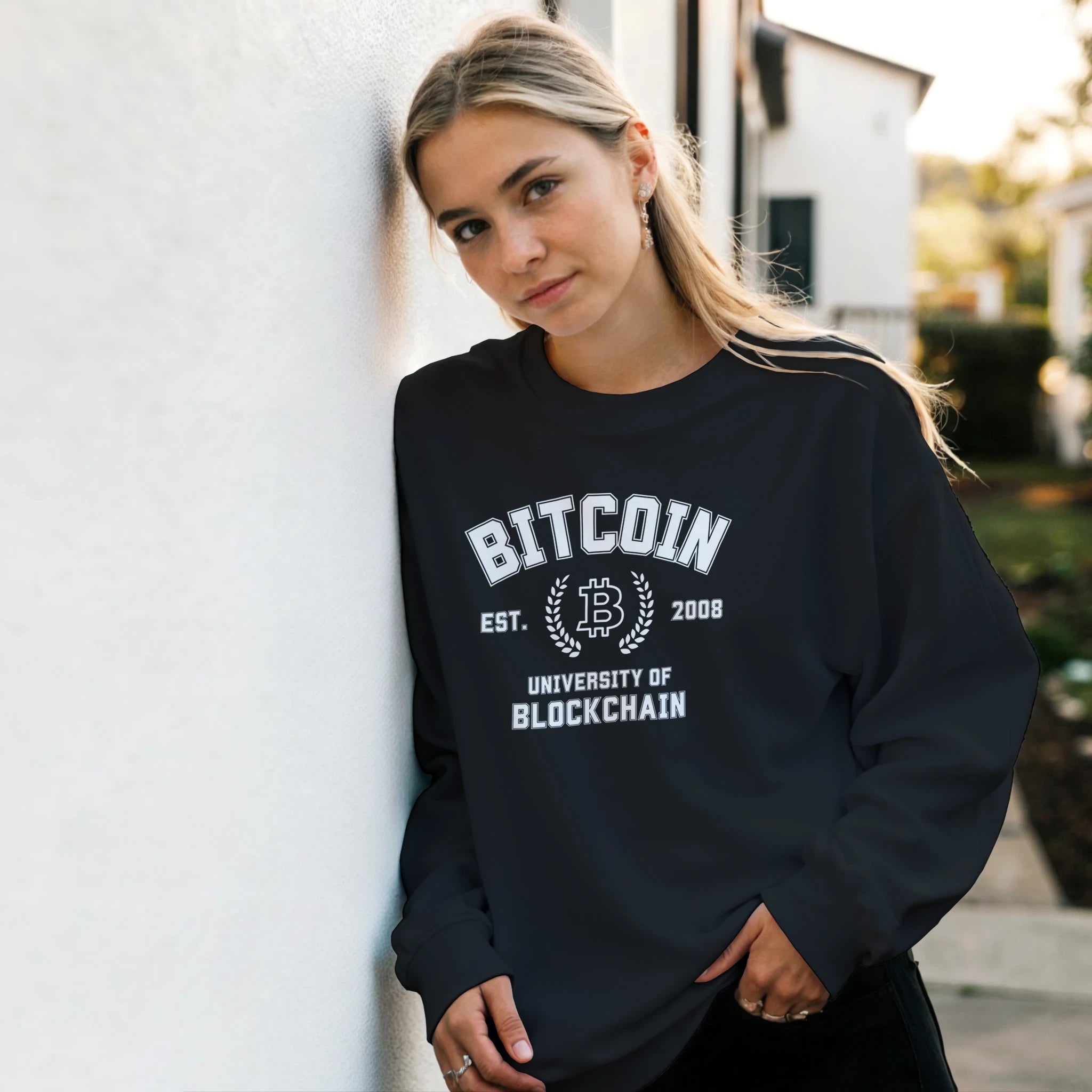 Person wearing a black sweatshirt with Bitcoin University of Blockchain text.