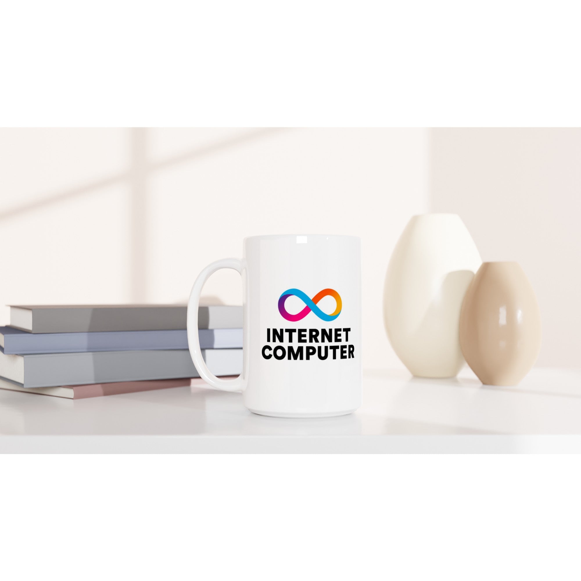 White mug with 'Internet Computer' logo on a white surface with books and decorative items.