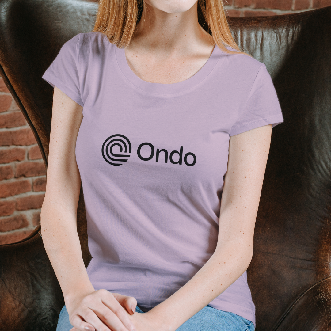 Person wearing a purple t-shirt with 'Ondo' logo sitting on a leather couch.