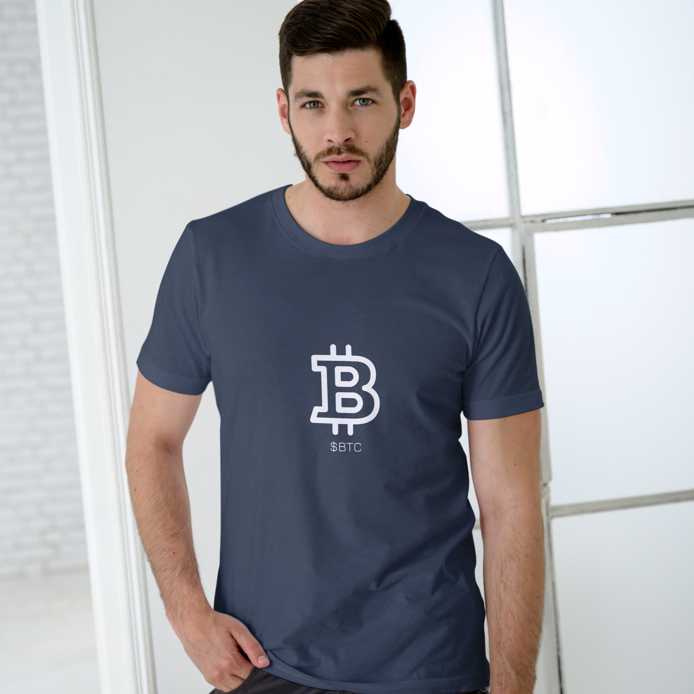 Man wearing a navy blue t-shirt with a Bitcoin logo on a light background