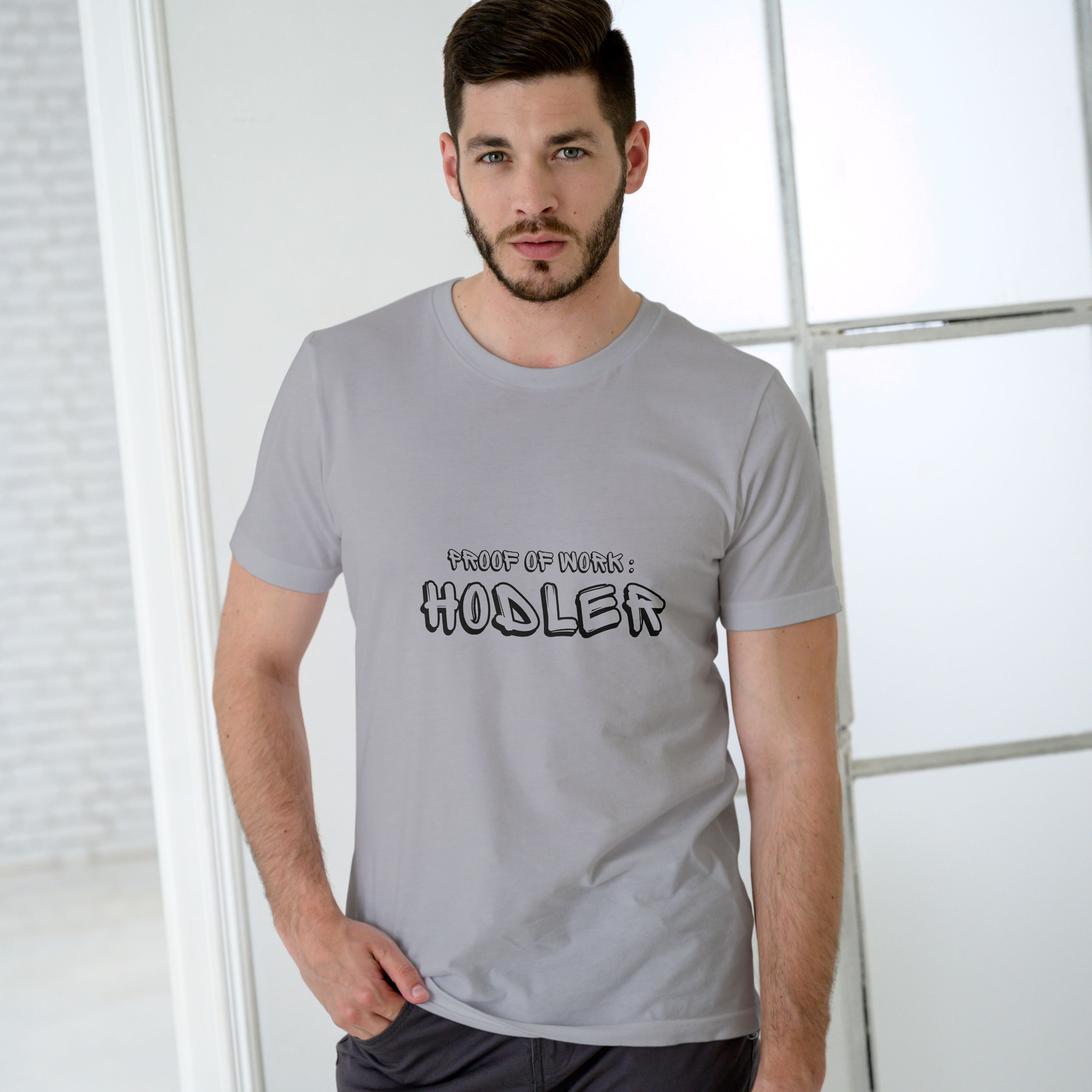 Man wearing a gray t-shirt with text in a modern indoor setting