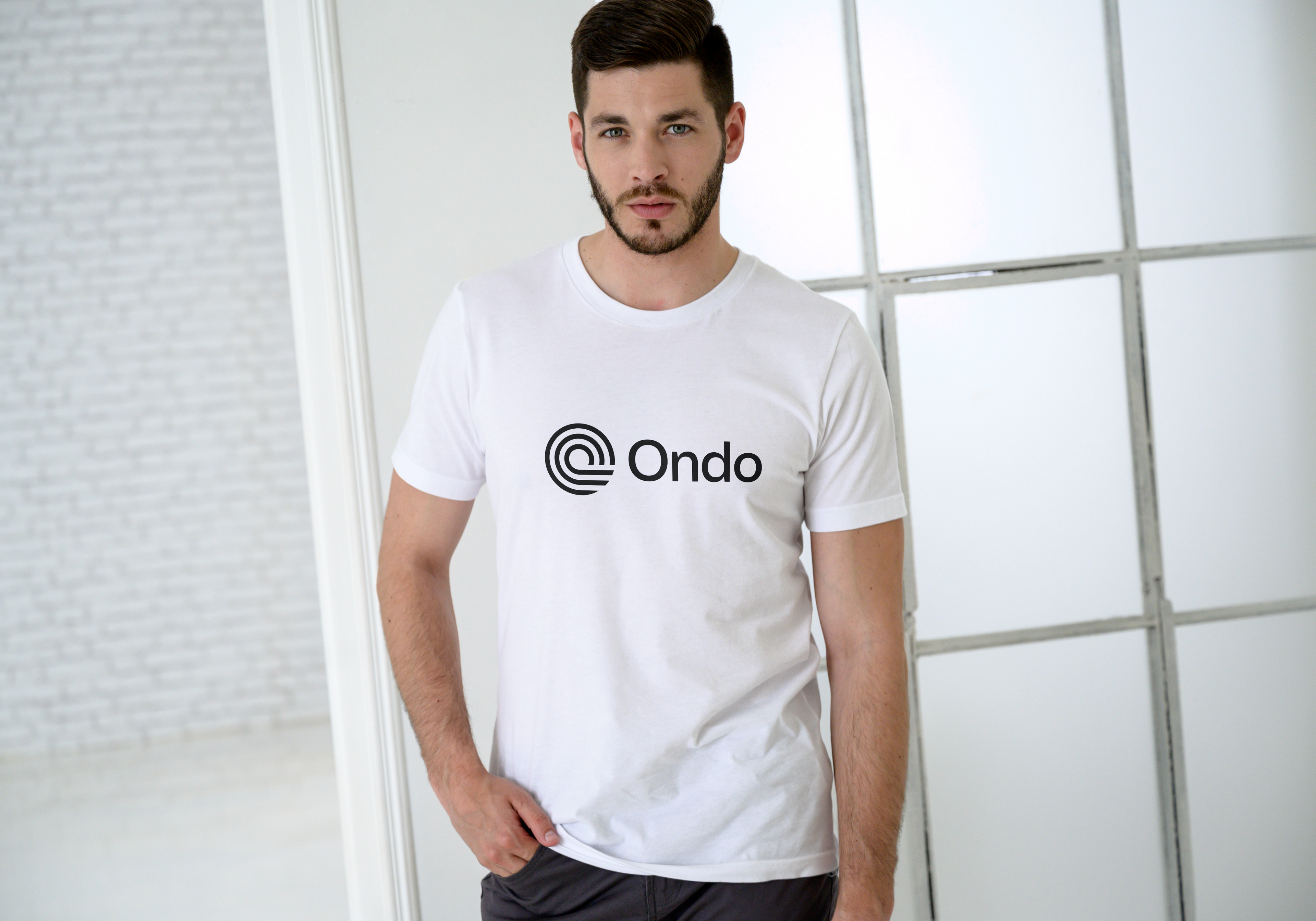 Man wearing a white t-shirt with 'Ondo' logo against a light background