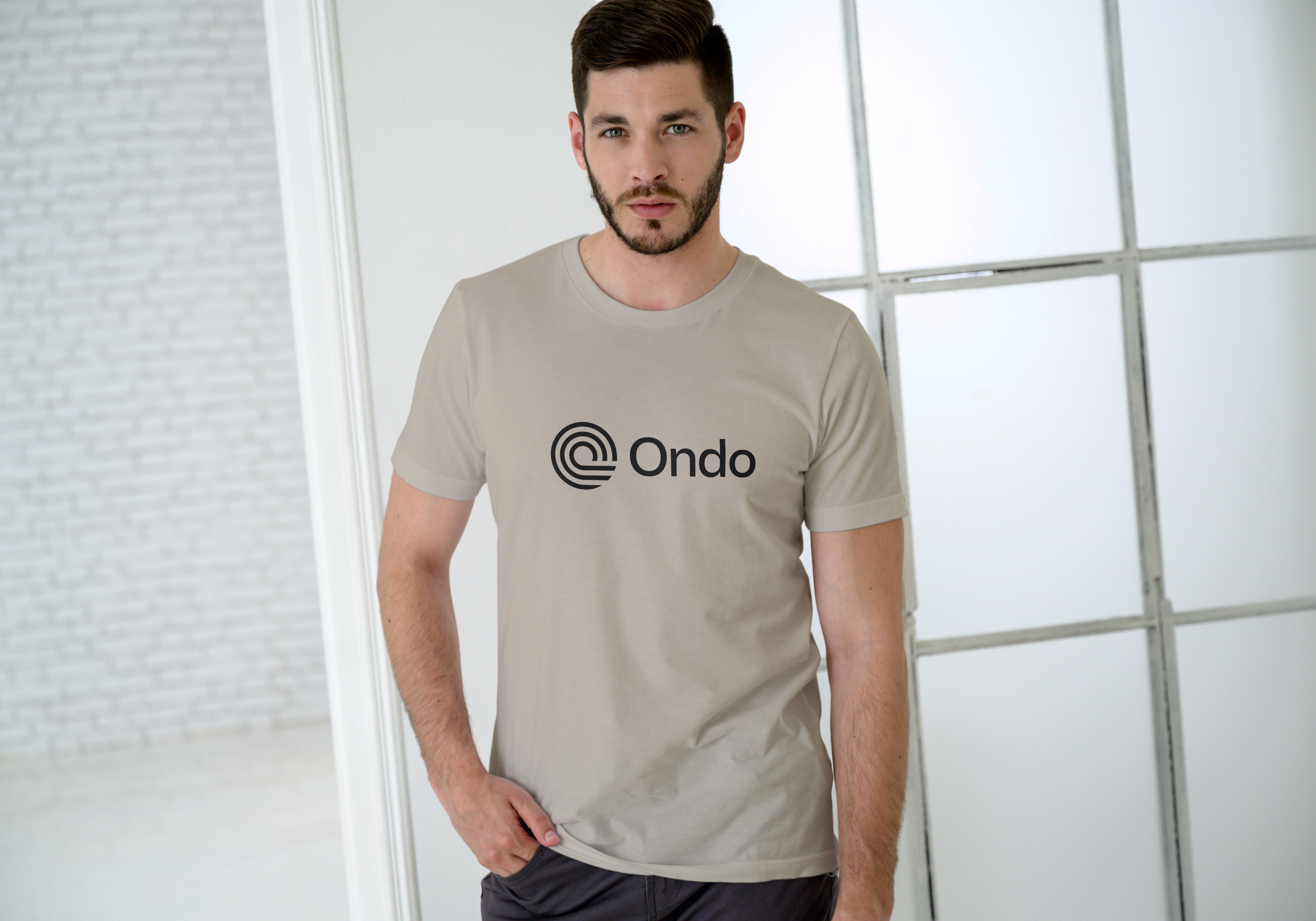 Man wearing a beige t-shirt with 'Ondo' logo against a light background