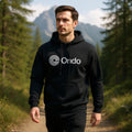 Man wearing a black hoodie with 'Ondo' logo in a forest setting