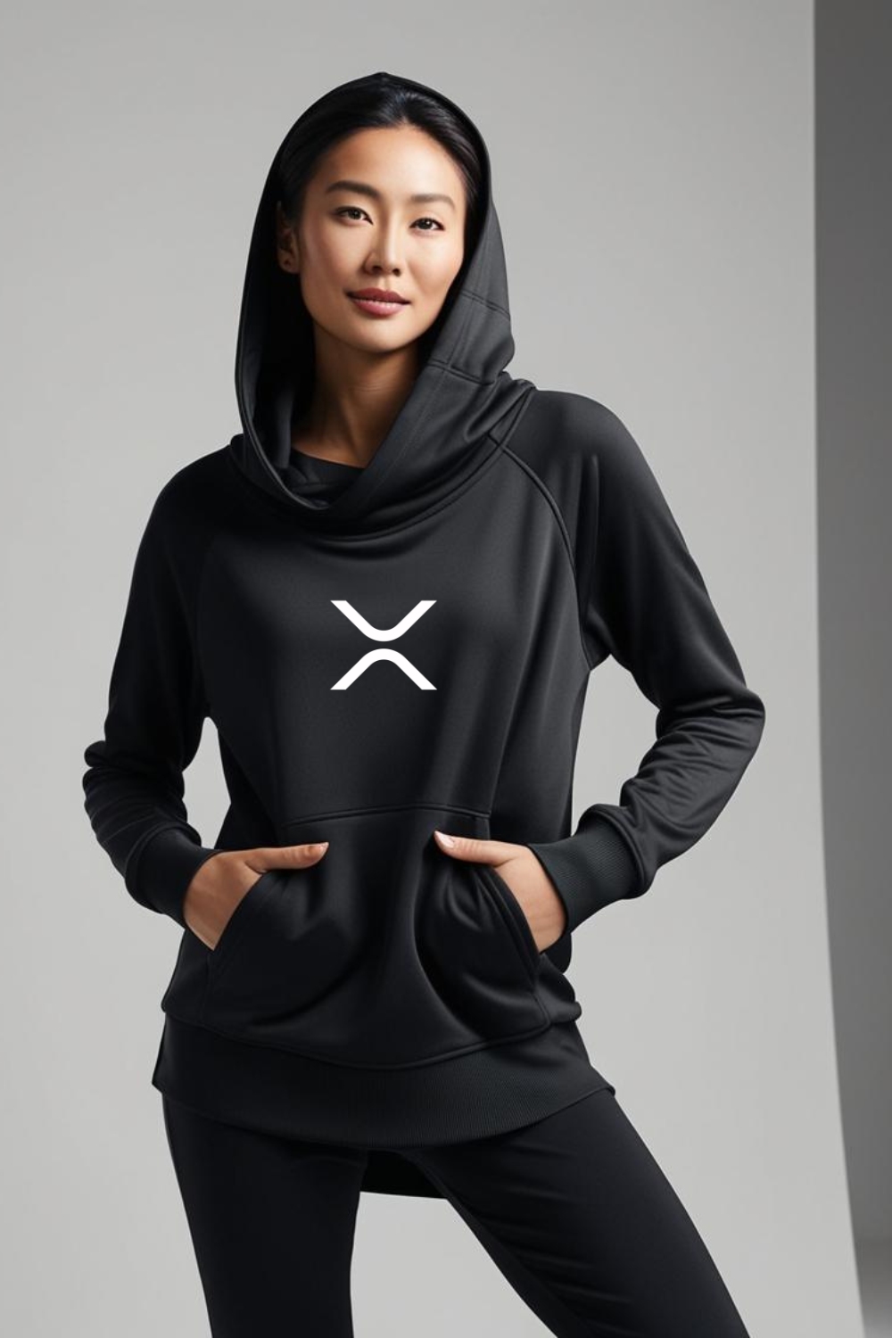 Person wearing a black hoodie with a logo on a gray background
