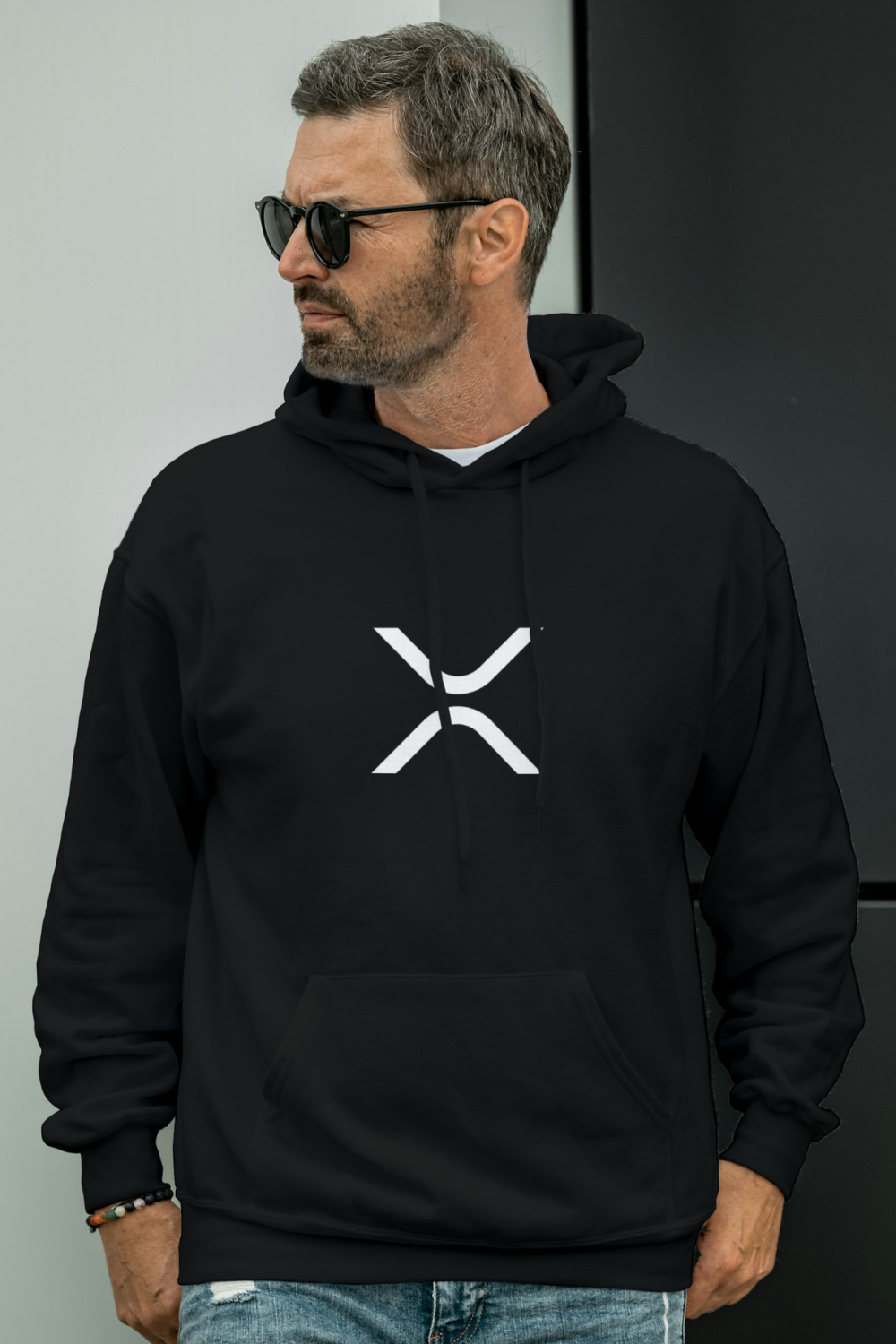 Man wearing a black hoodie with a white logo against a plain background