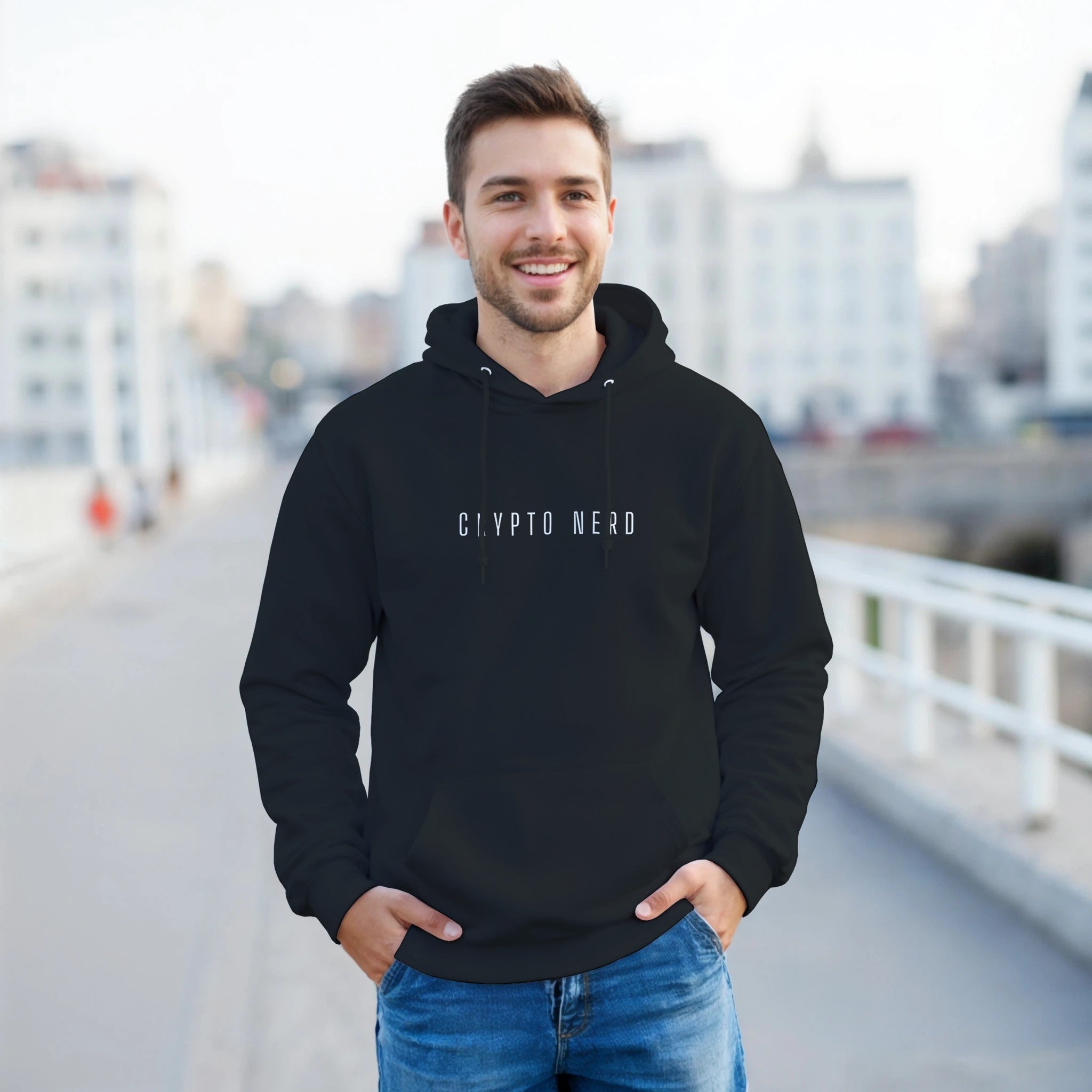 Man wearing a black hoodie with 'CRYPTO NERD' text, standing on a bridge with a cityscape background.