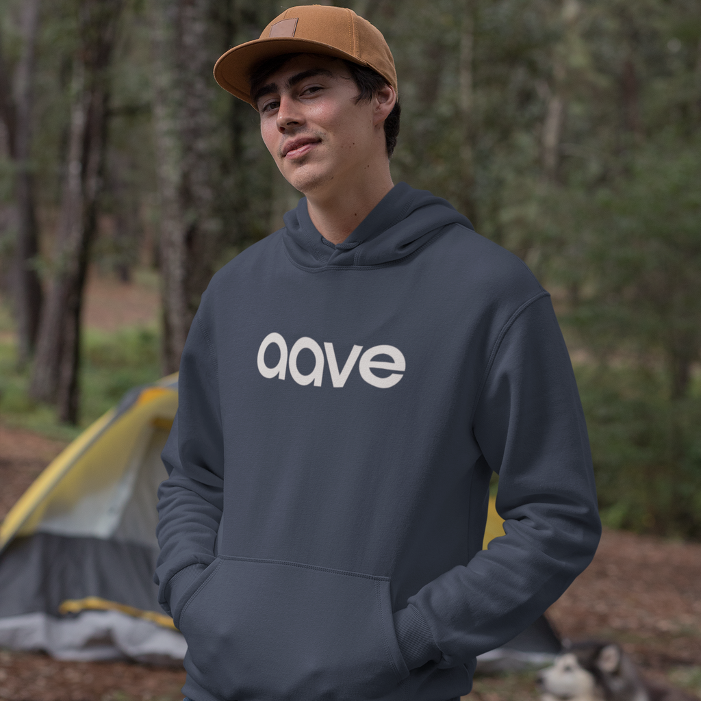Person wearing a dark hoodie with 'ava' logo outdoors, with a dog and camping gear in the background.