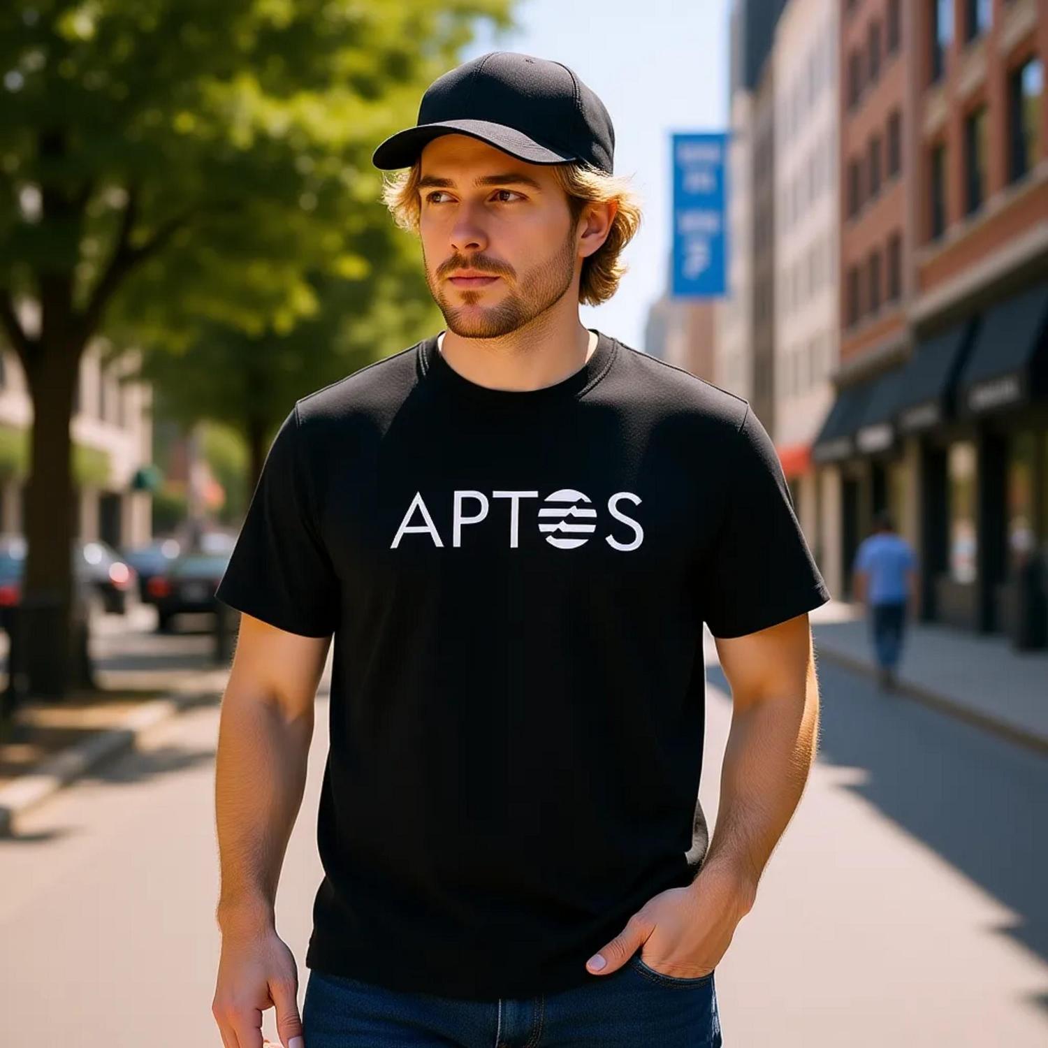 Man wearing a black t-shirt with 'Aptos' logo on a city street