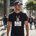 Man walking on a city street wearing a black t-shirt with 'Bad Bitcoin' graphic.