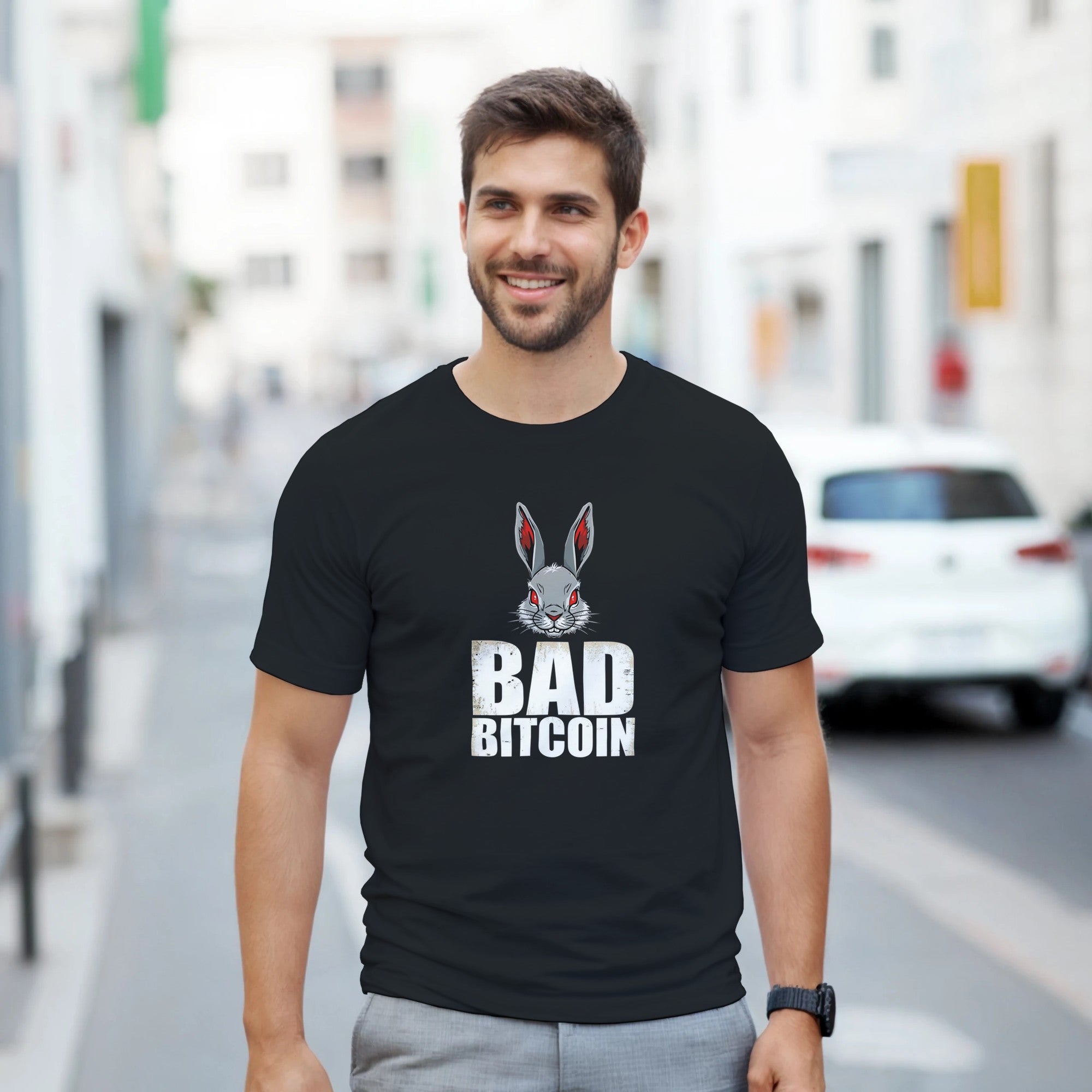 Man wearing a black t-shirt with 'Bad Bitcoin' graphic on a city street
