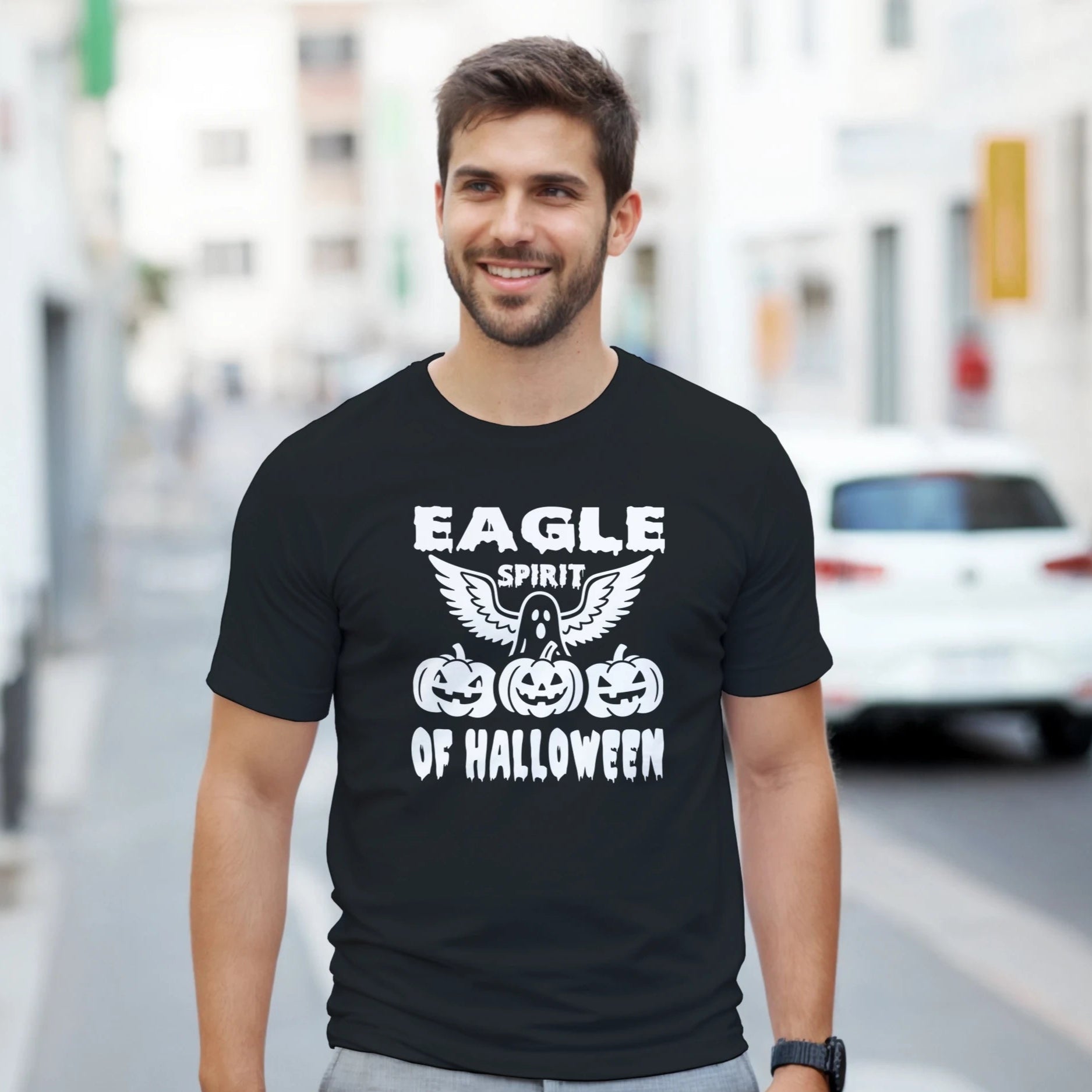 Man wearing a black t-shirt with Halloween-themed design on a city street.