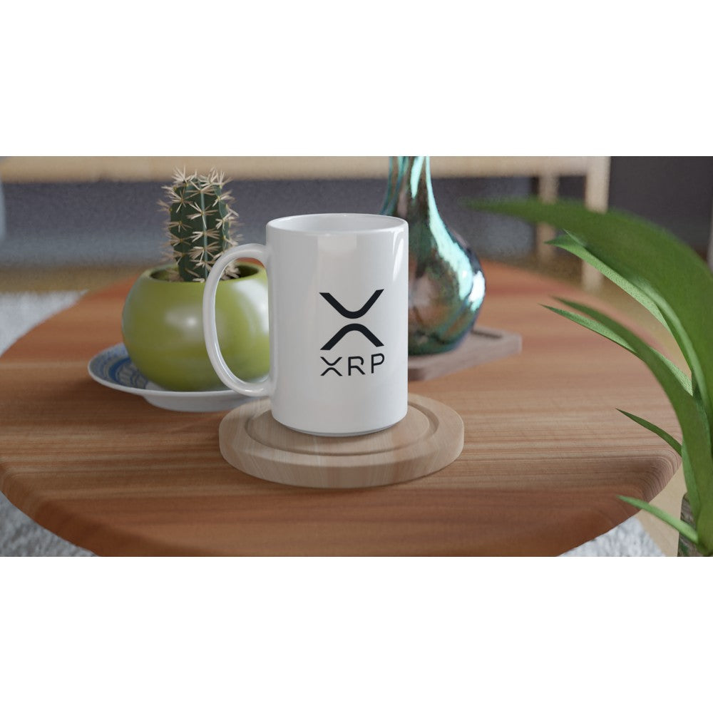 White mug with XRP logo on a wooden table with decorative items