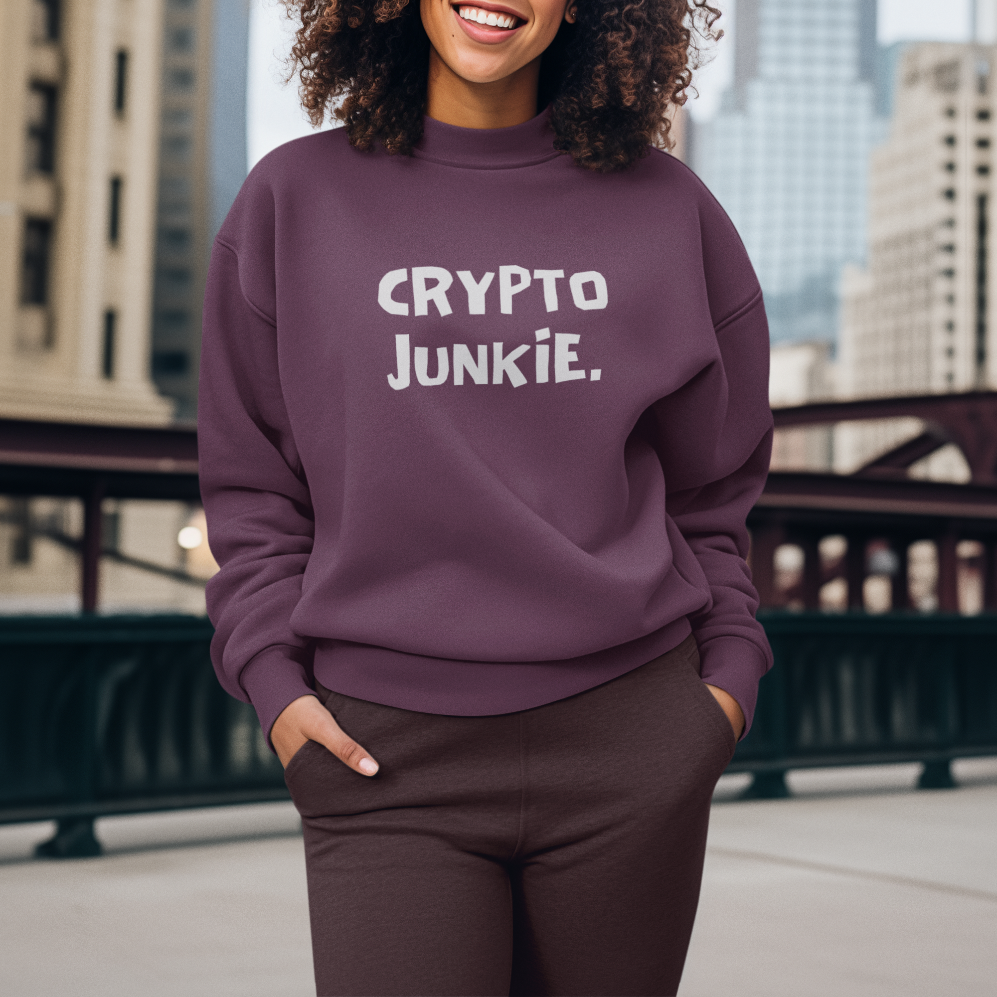 Person wearing a purple sweatshirt with 'CRYPTO JUNKIE' text, standing in an urban setting.