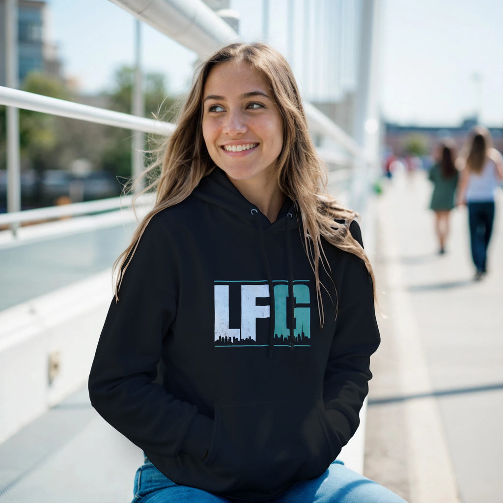 Woman wearing a black hoodie with 'LFG' logo sitting outdoors on a bridge