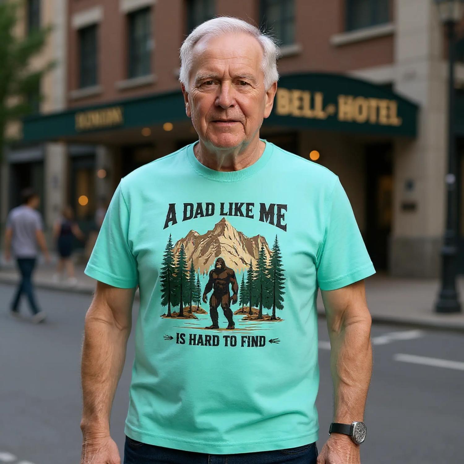 Man wearing a light blue t-shirt with a graphic and text, standing on a city street.