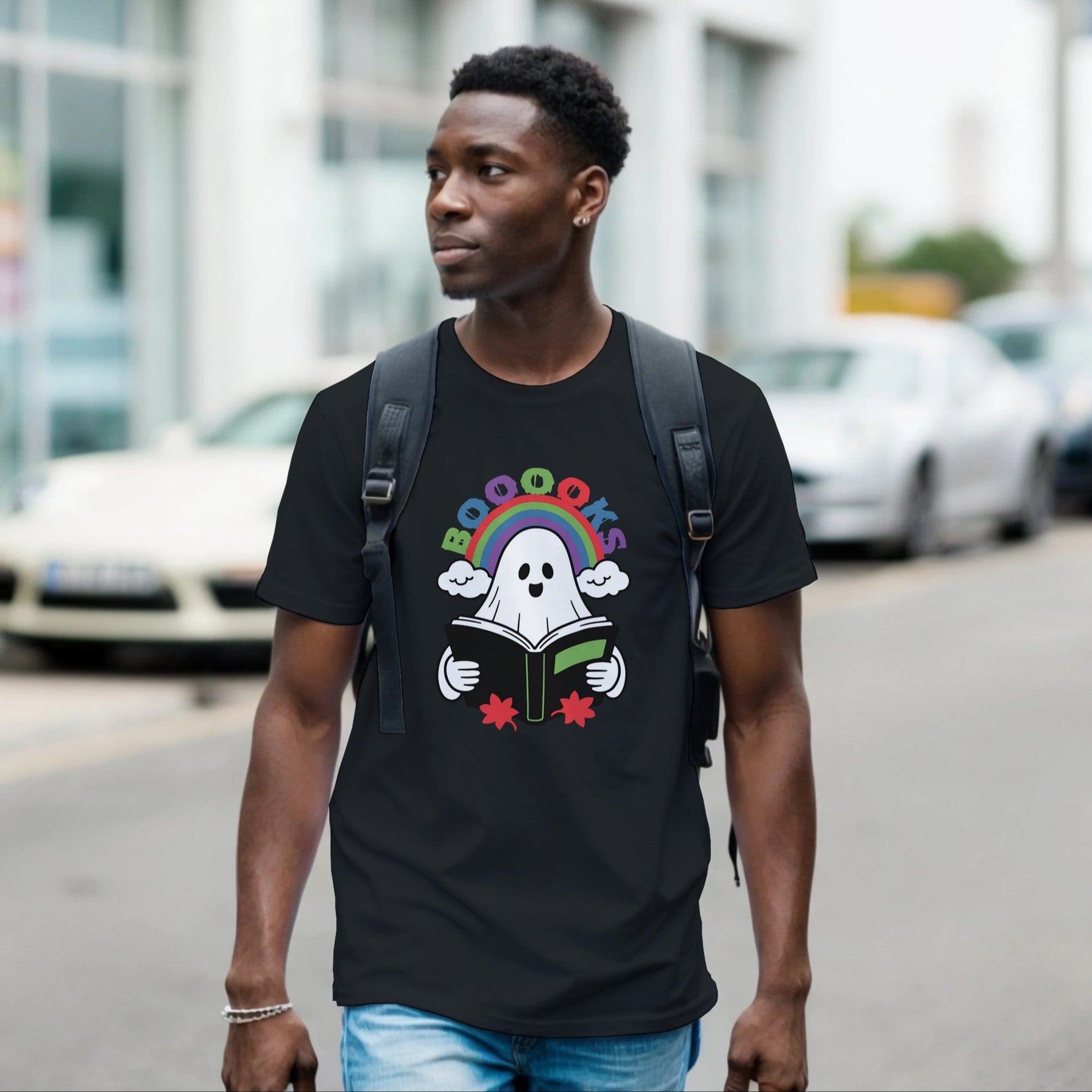 Man wearing a black t-shirt with a colorful graphic design walking on a street.