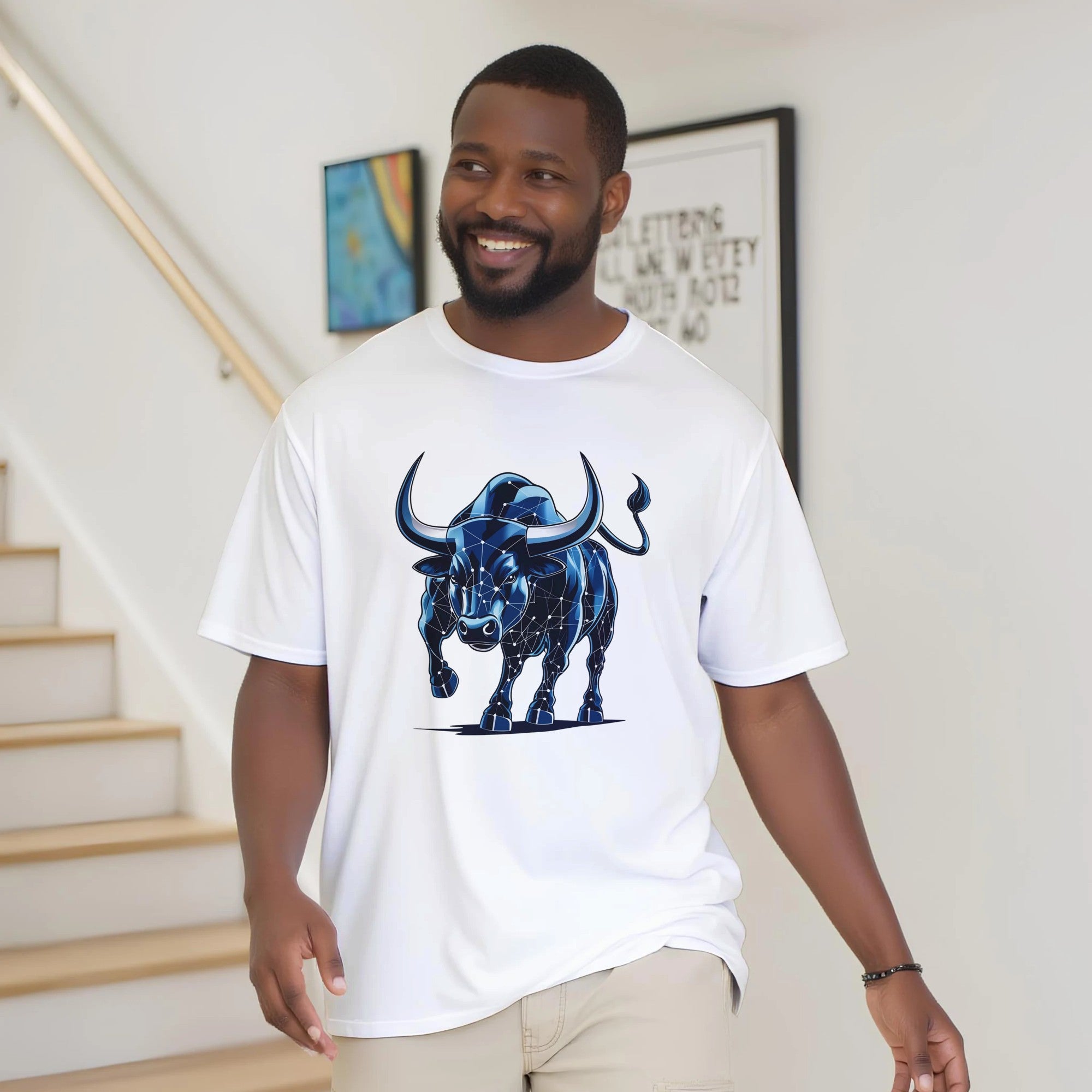 Man wearing a white t-shirt with a blue bull graphic in a home setting