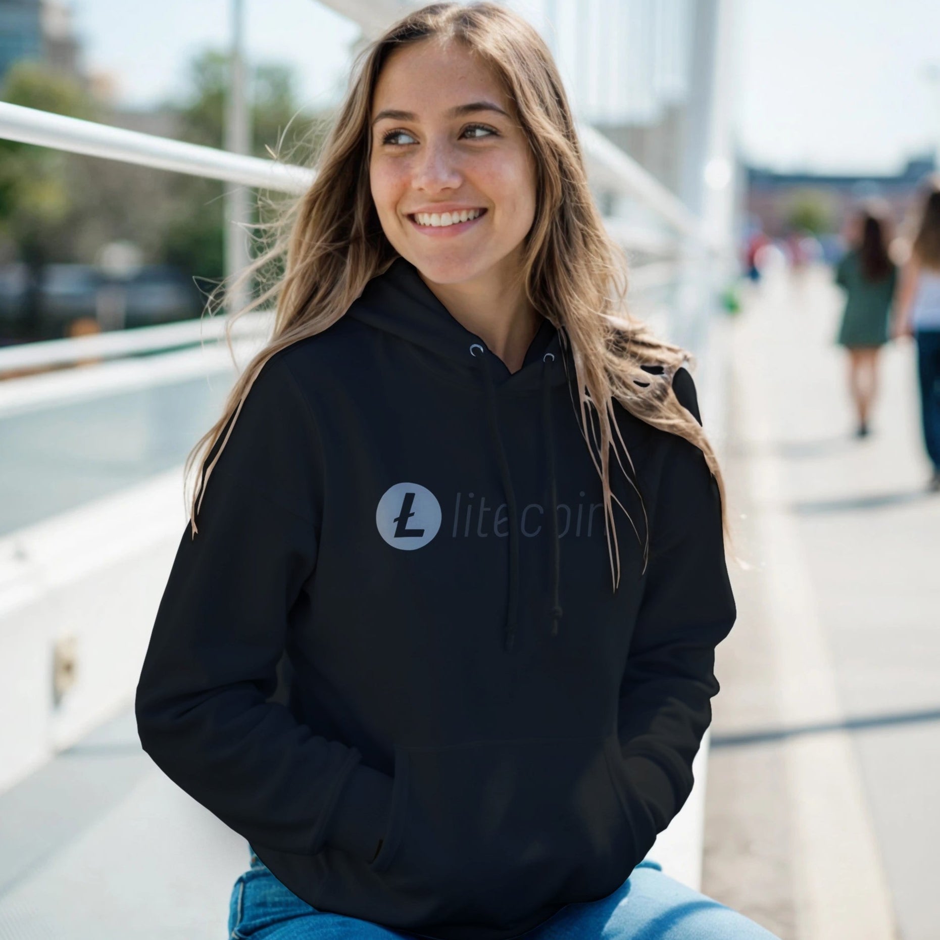 Person wearing a black hoodie with a Litecoin logo outdoors
