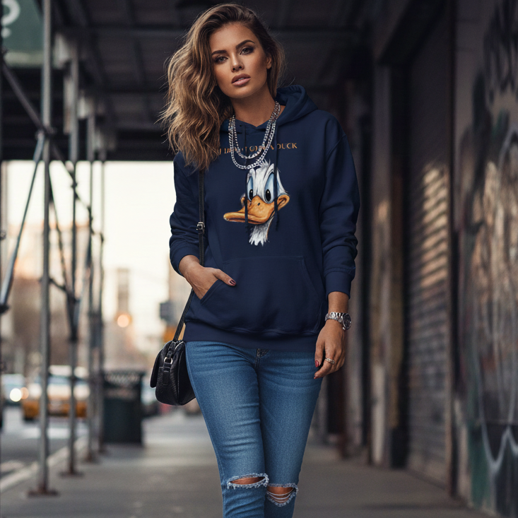 Woman wearing a navy hoodie with a graphic design, blue jeans, and white sneakers on a city street.