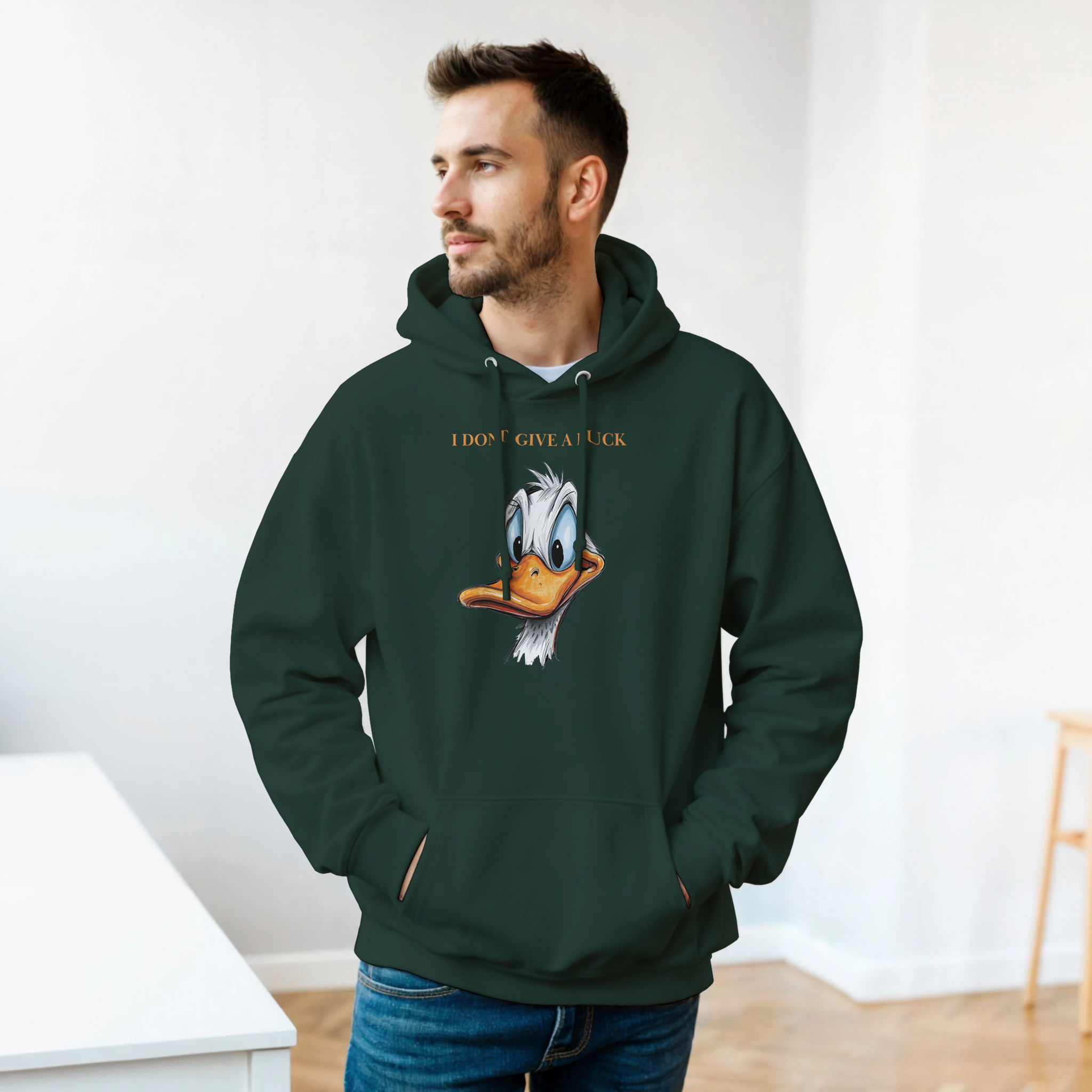 Man wearing a green hoodie with a cartoon character design indoors.
