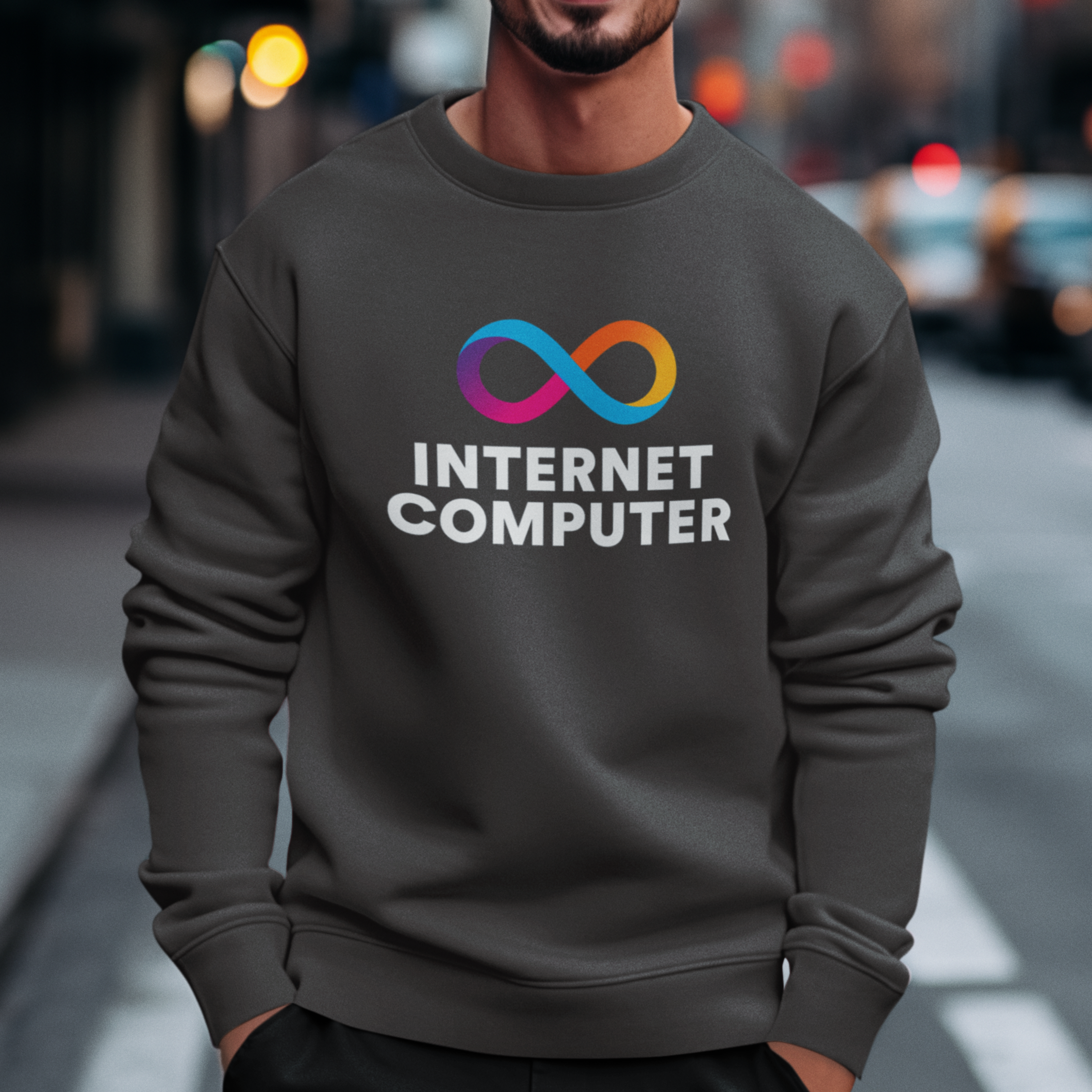 Person wearing a dark gray sweatshirt with 'Internet Computer' logo on a city street.