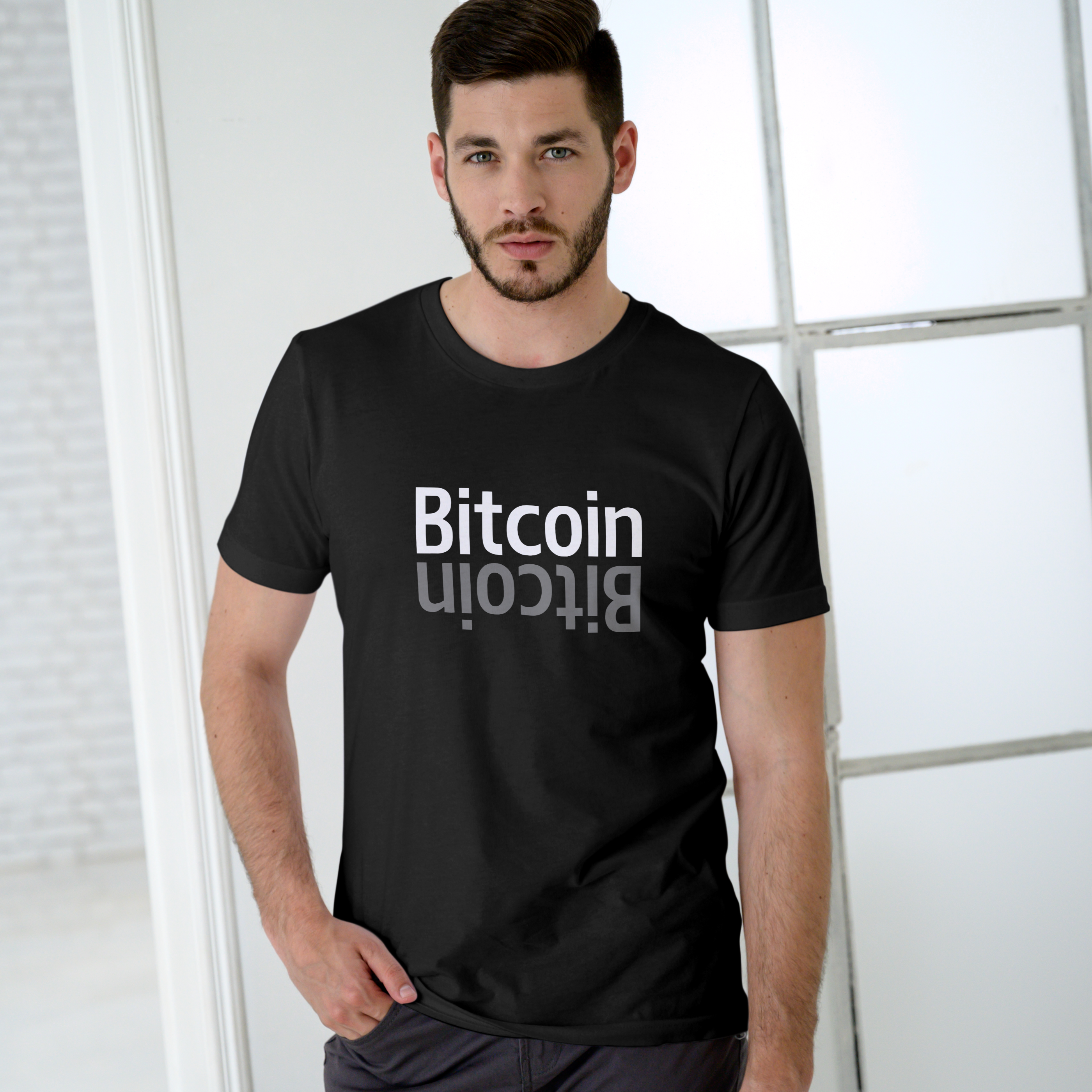Person wearing a black t-shirt with 'Bitcoin' printed on it against a light background