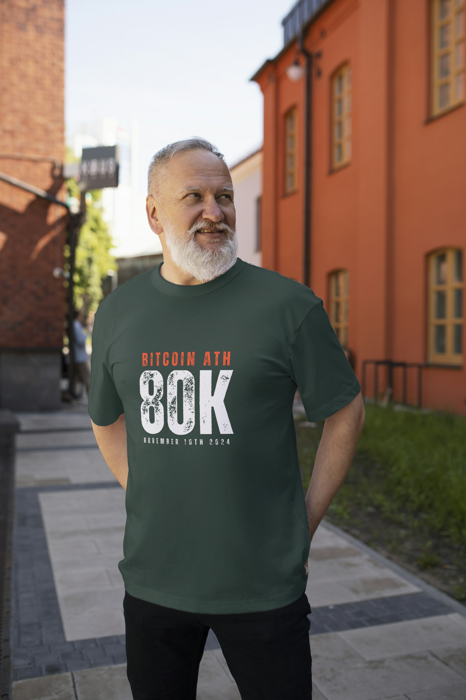 Man wearing a green t-shirt with Bitcoin text standing on a street.