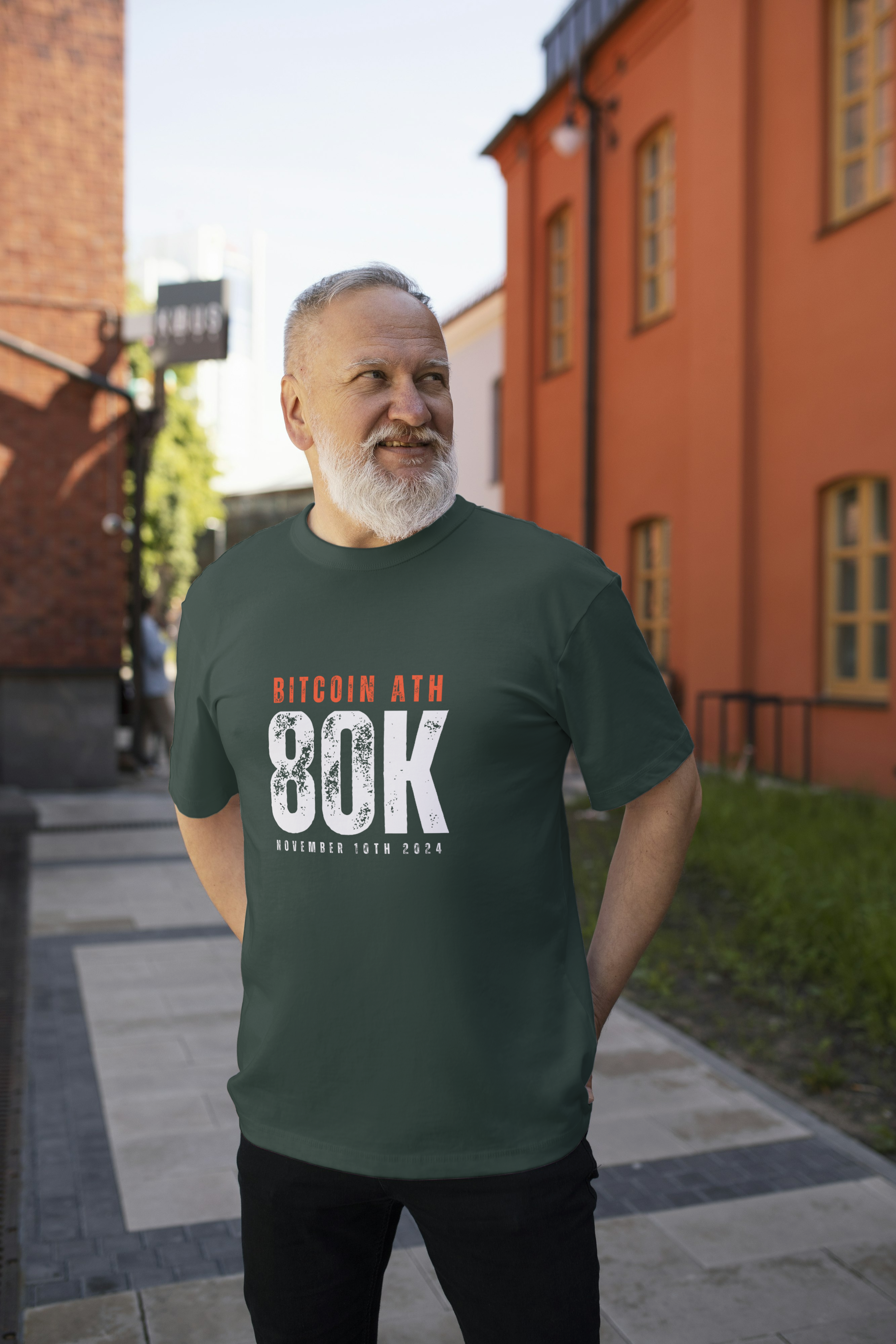 Man wearing a green t-shirt with Bitcoin text standing on a street.