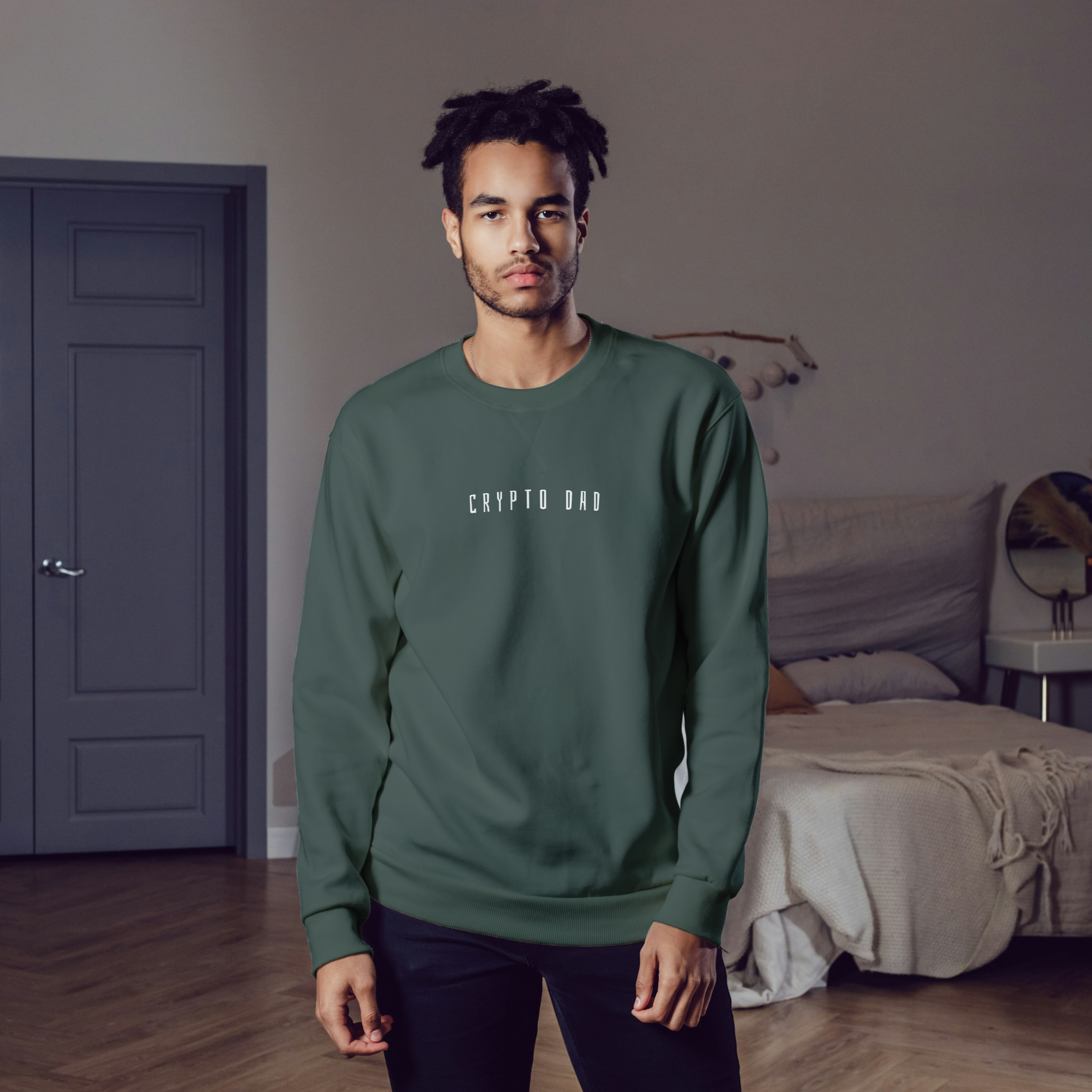 Man wearing a green sweatshirt with text in a bedroom setting