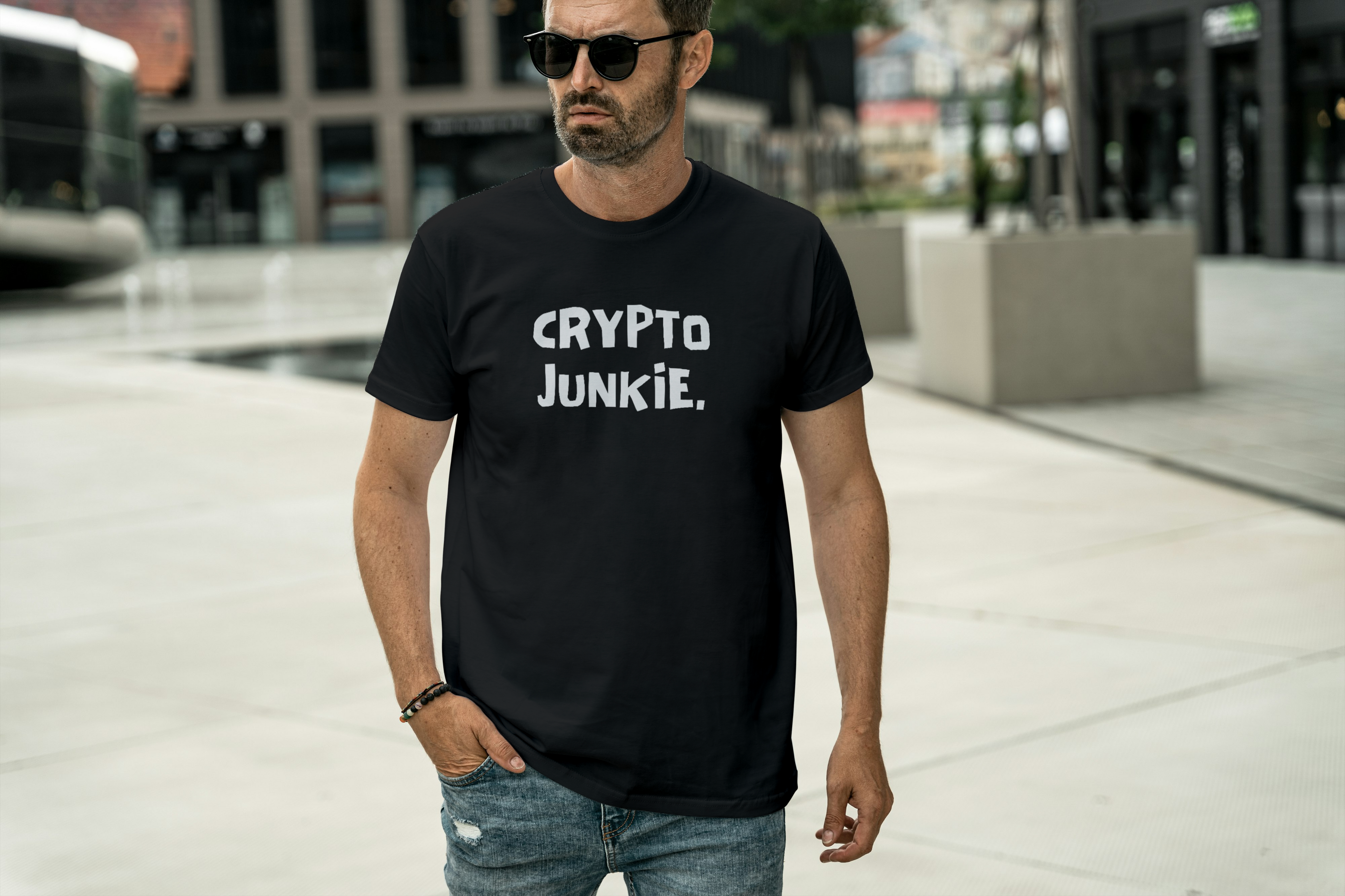 Man wearing a black t-shirt with 'Crypto Junkie' text in an urban setting