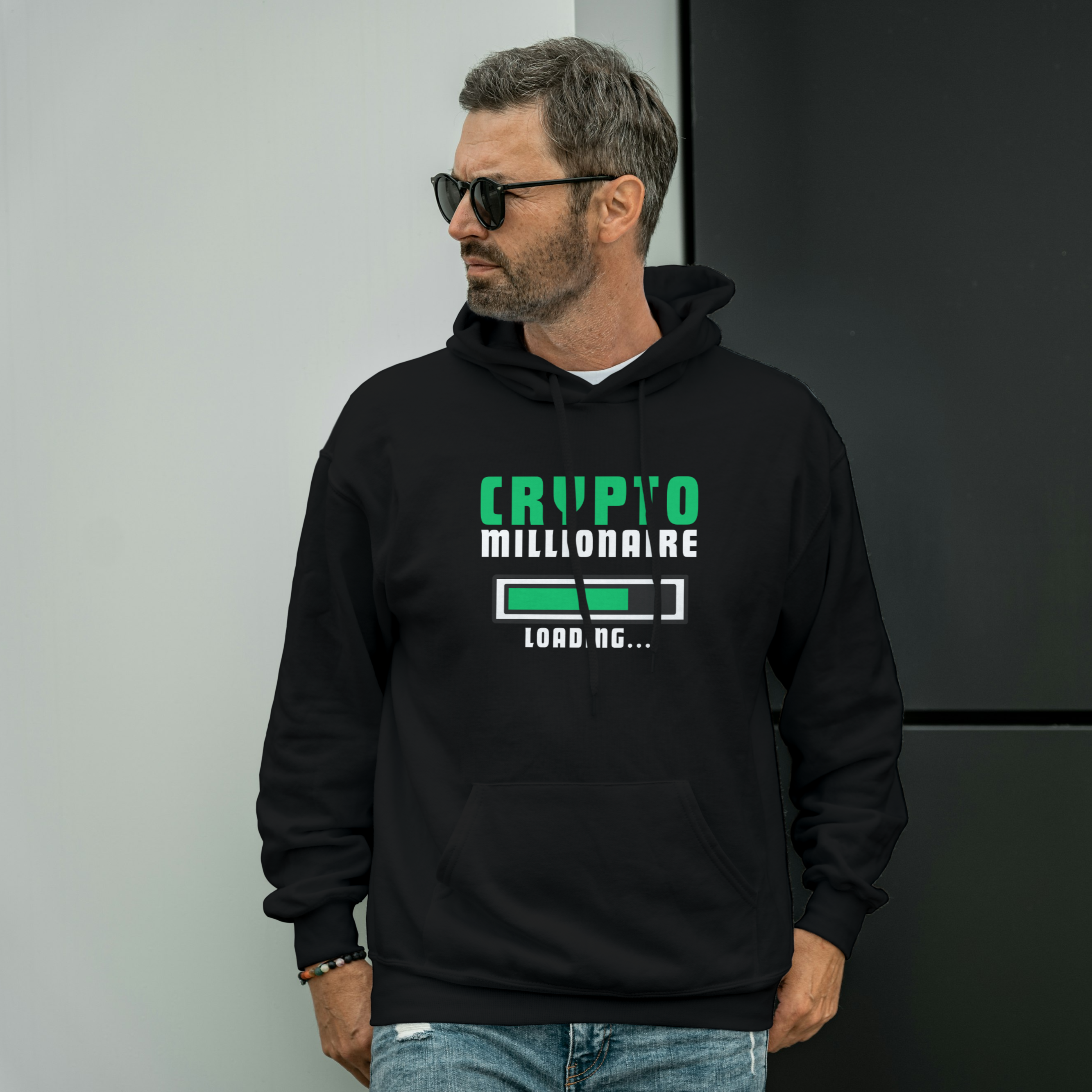 Man wearing a black hoodie with 'Crypto Millionaire' text, standing against a plain background